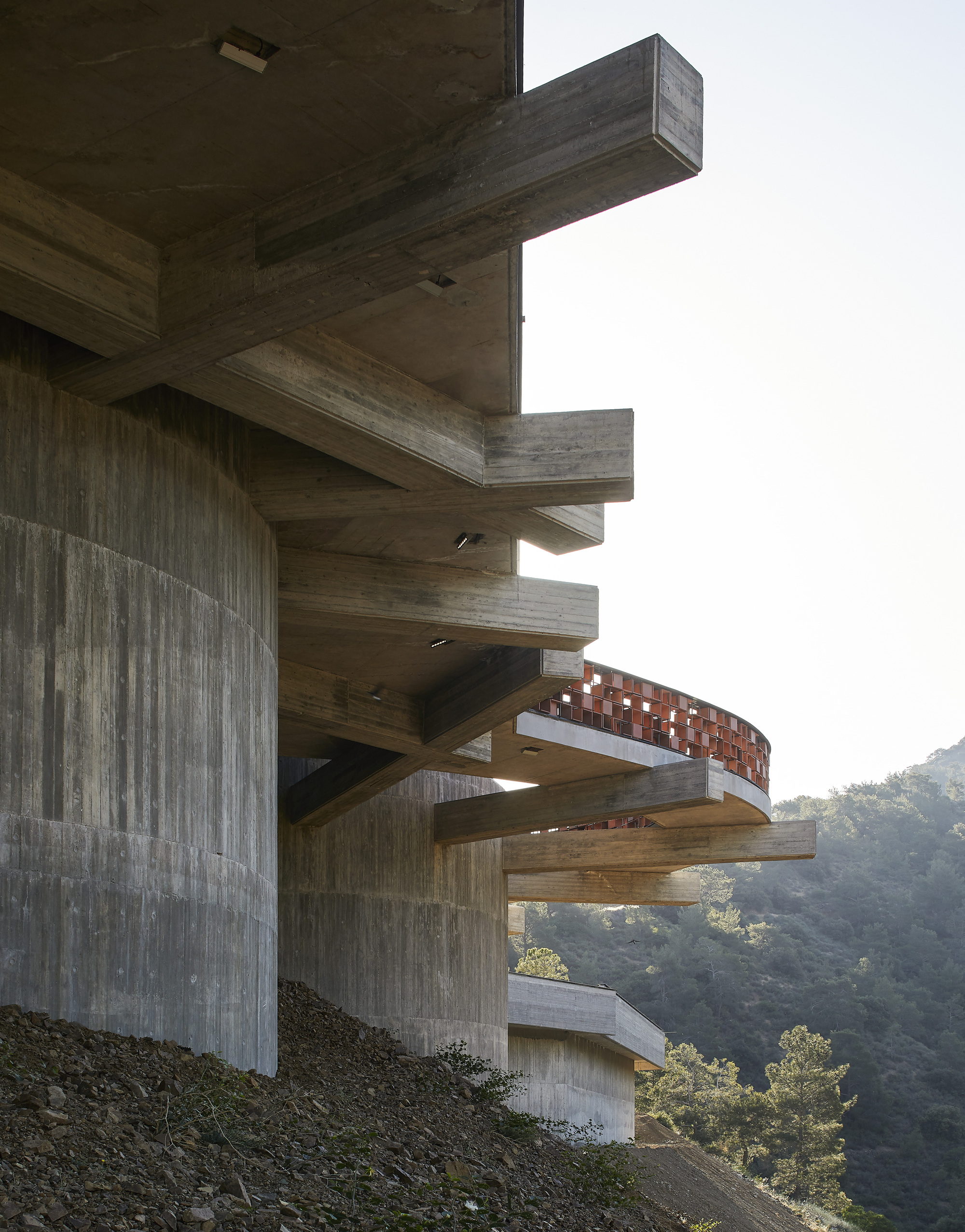 Stacked concrete cantilevers extending from board-formed walls overlooking the valley