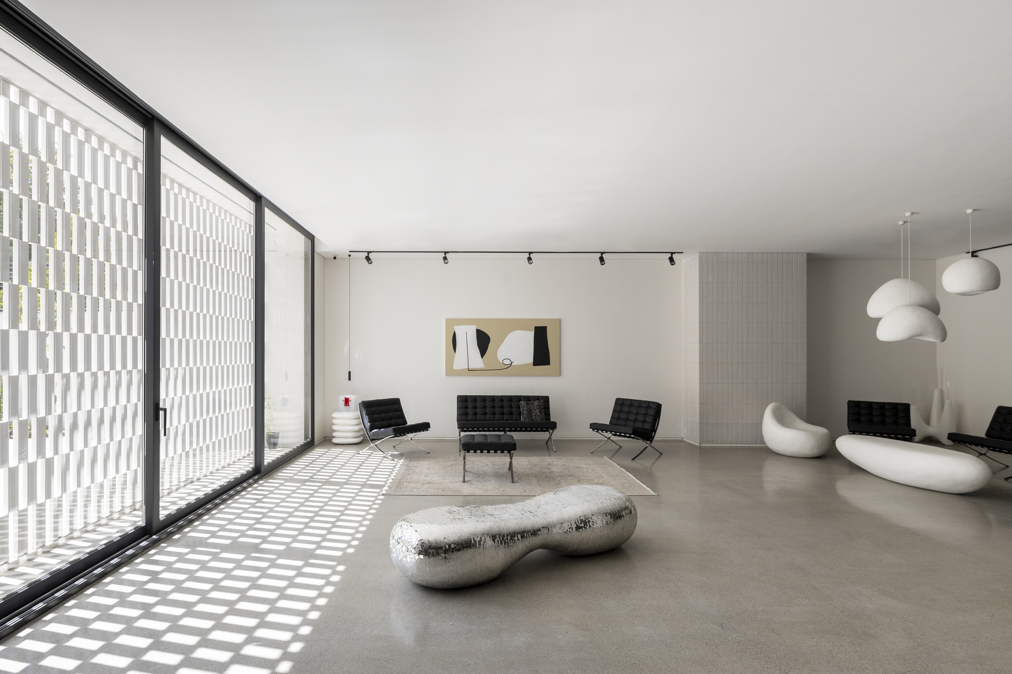 Interior living space with floor-to-ceiling glazing casting geometric shadow patterns across polished concrete floors