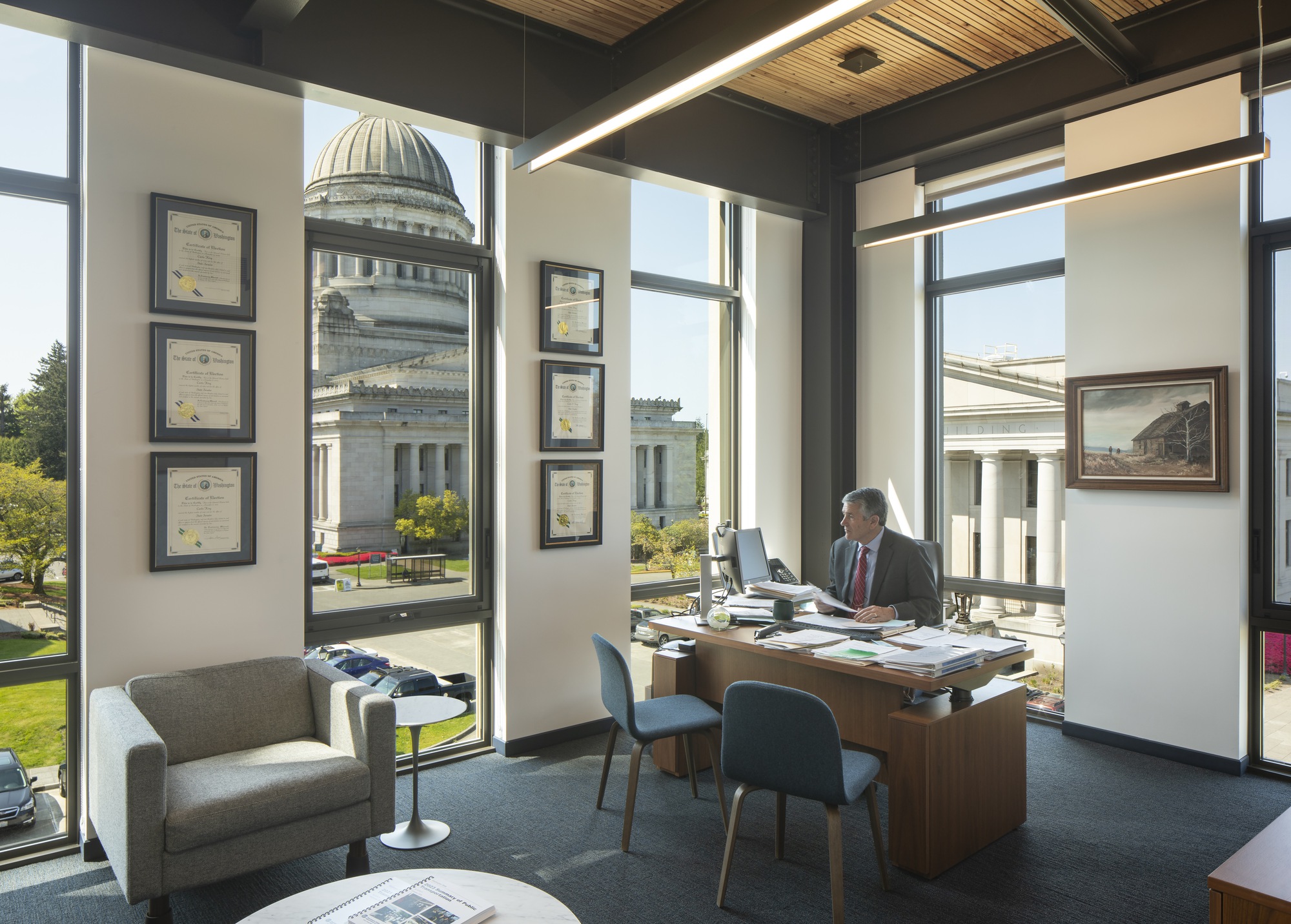 Corner office with dark steel framing and floor-to-ceiling windows overlooking a domed building