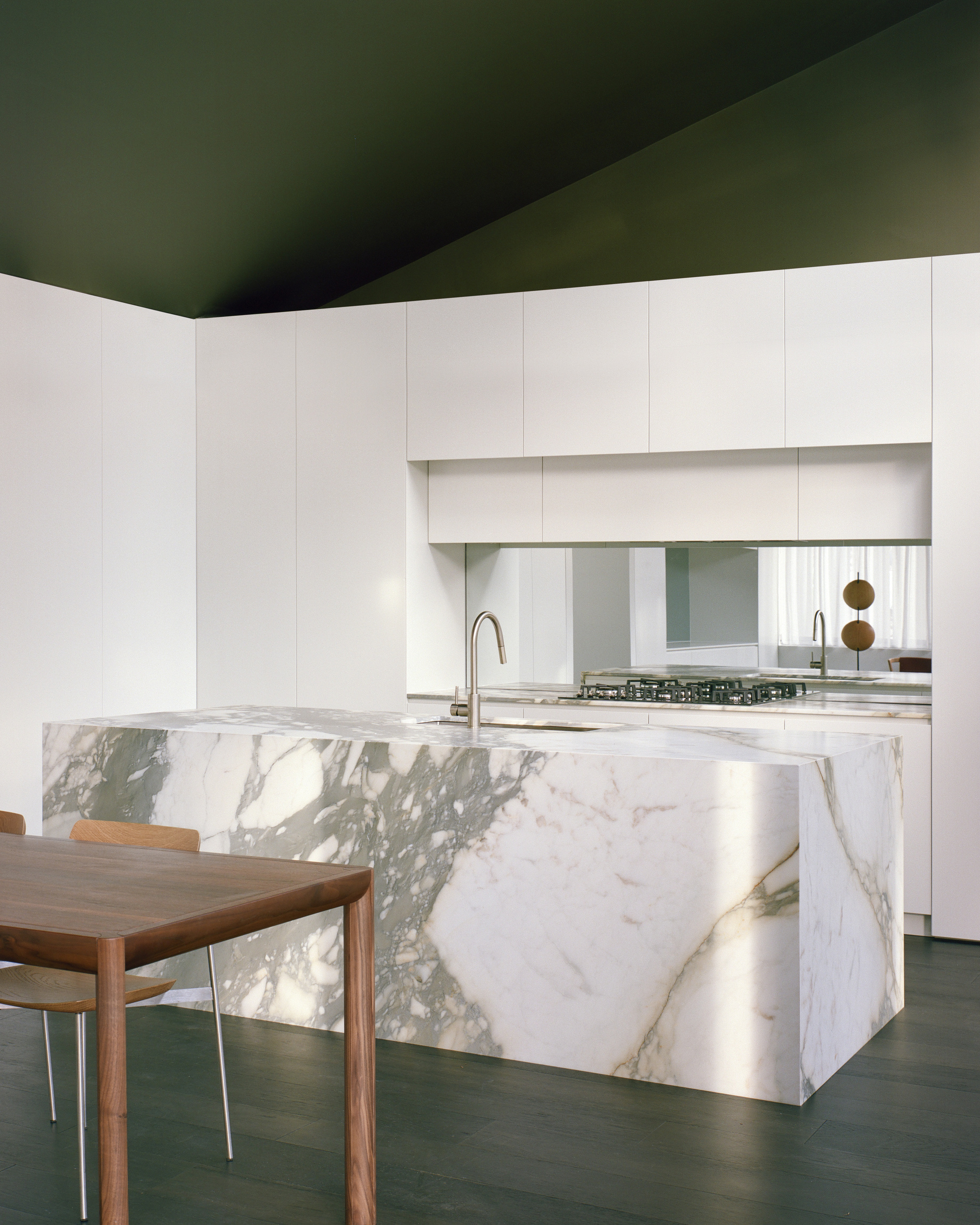 Close-up of the veined marble island and backsplash reflecting daylight from the window
