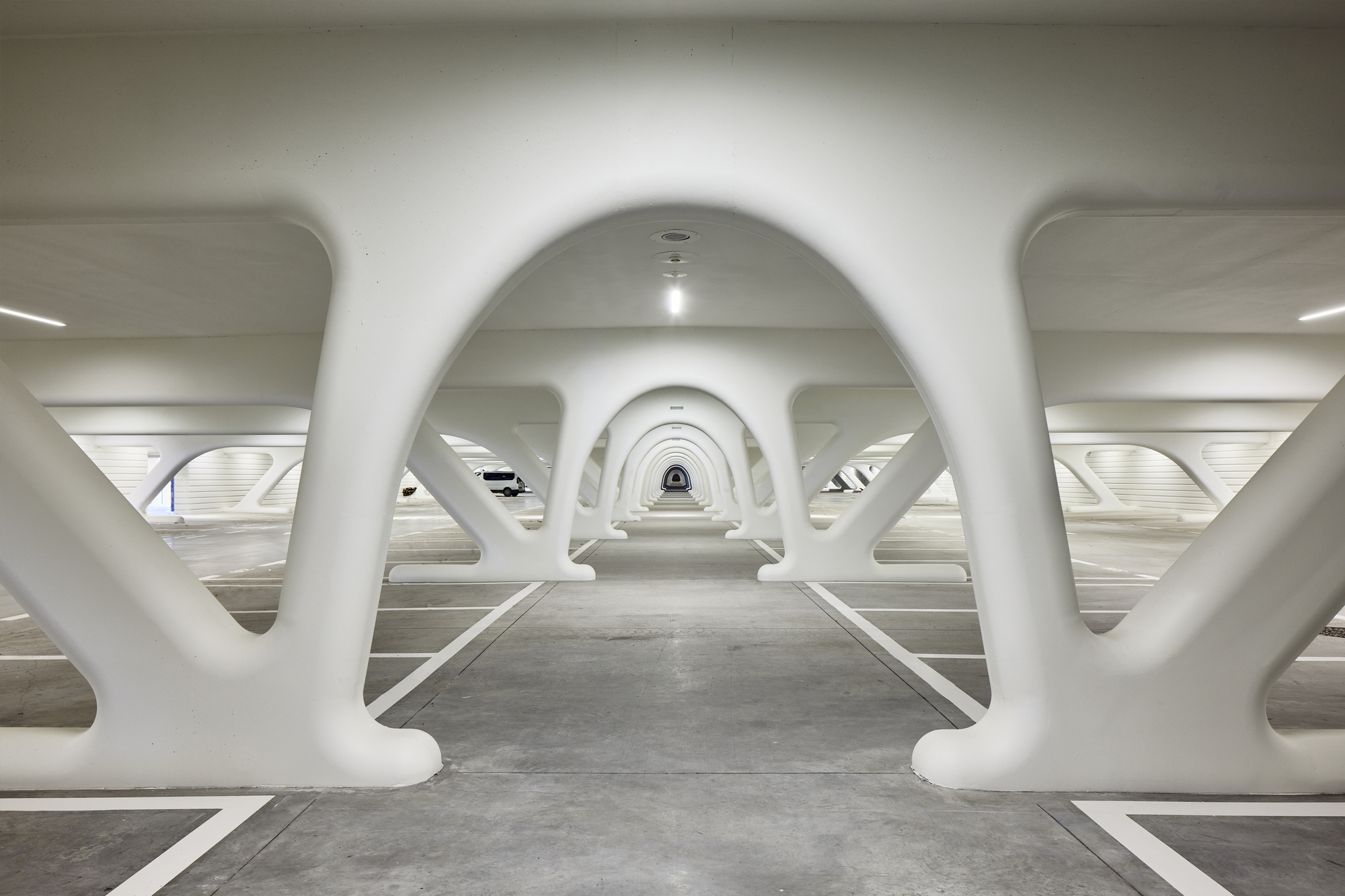 Underground pedestrian passage with repeating white arched structural frames creating rhythmic perspective