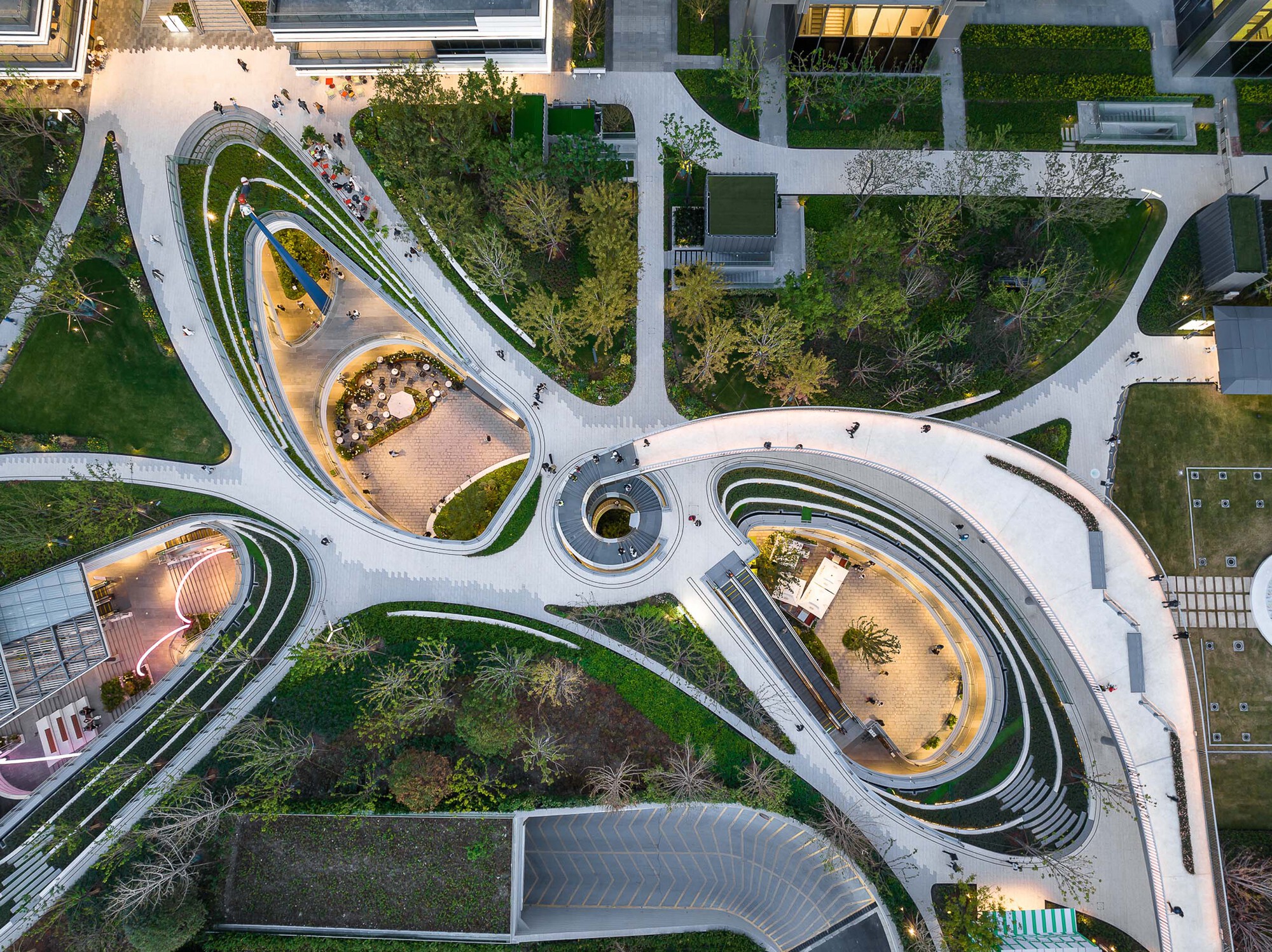 Aerial view of the curving white pedestrian pathways threading through sunken courtyards and planted beds