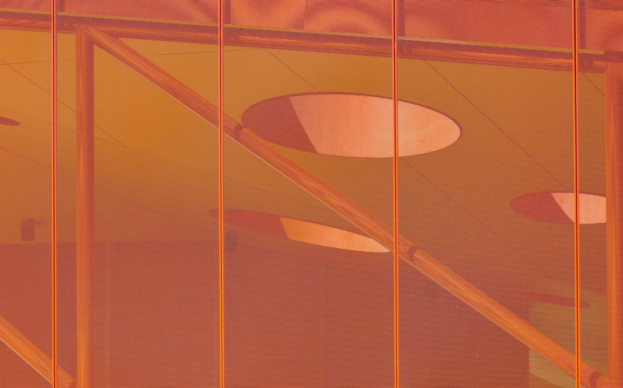 Translucent orange panel showing shadows of interior handrails and circular ceiling openings