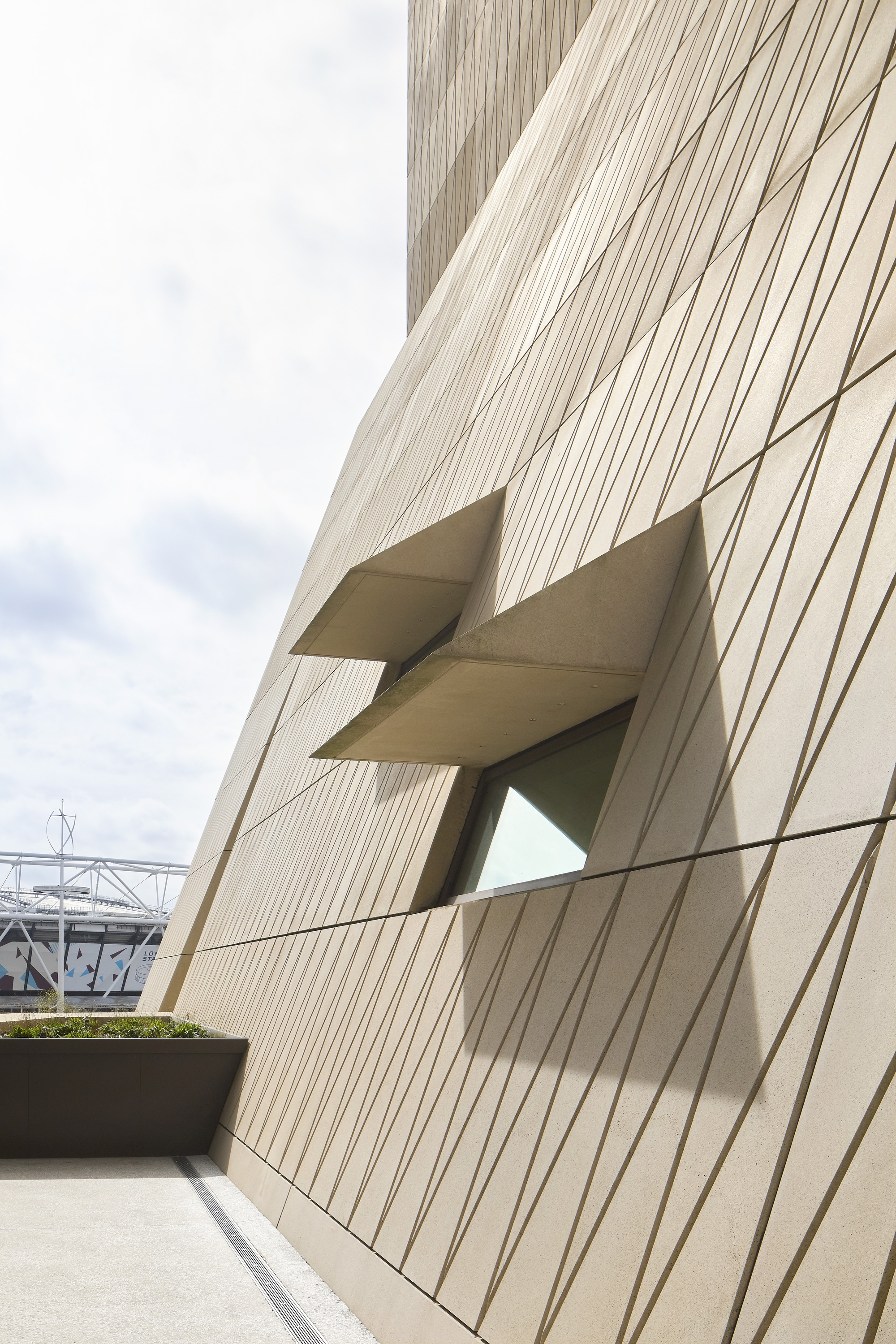 Detail of the angular window recess cutting through the vertically ribbed facade panels