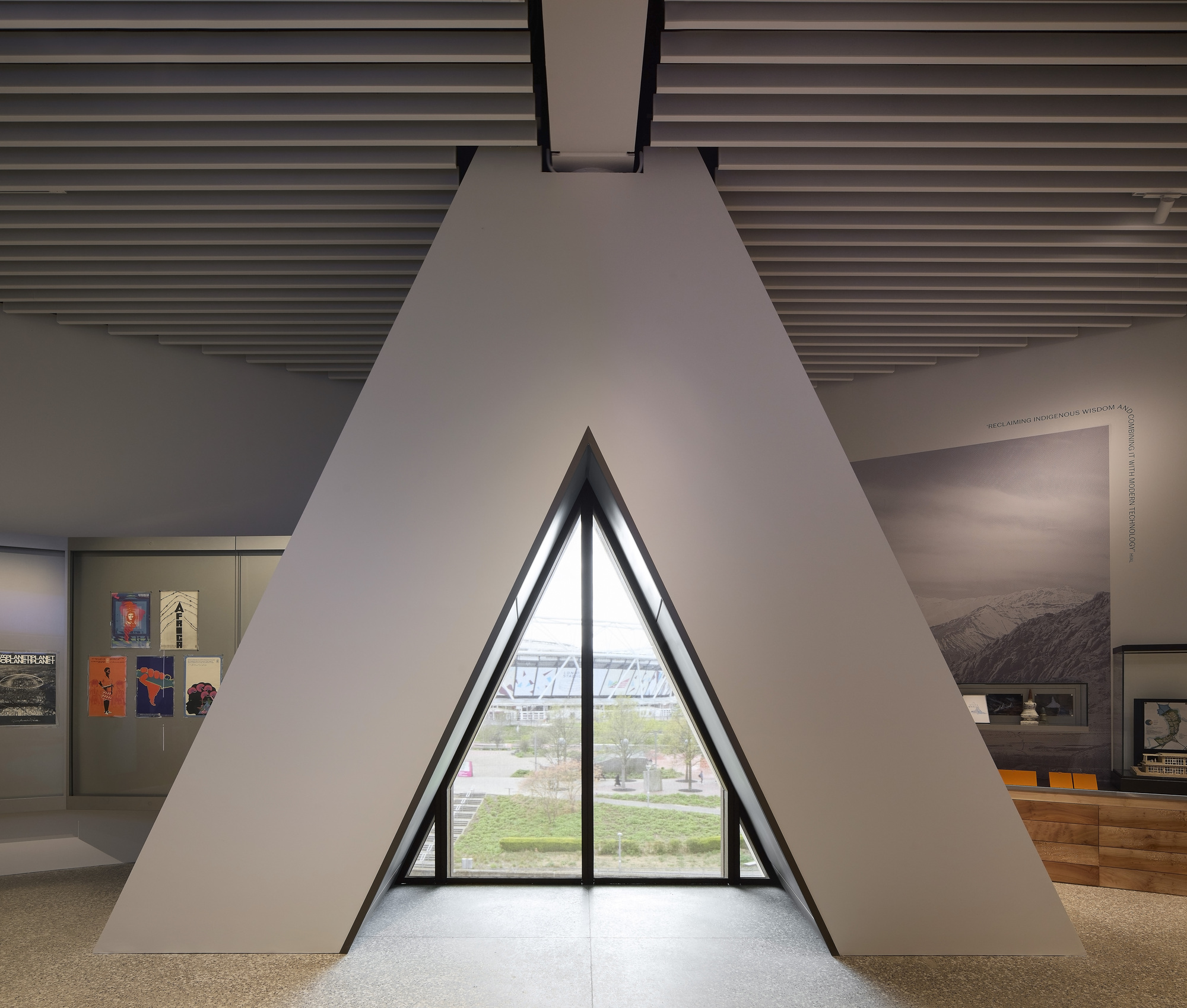 Triangular window alcove framing a view of the landscape with gallery displays on adjacent walls