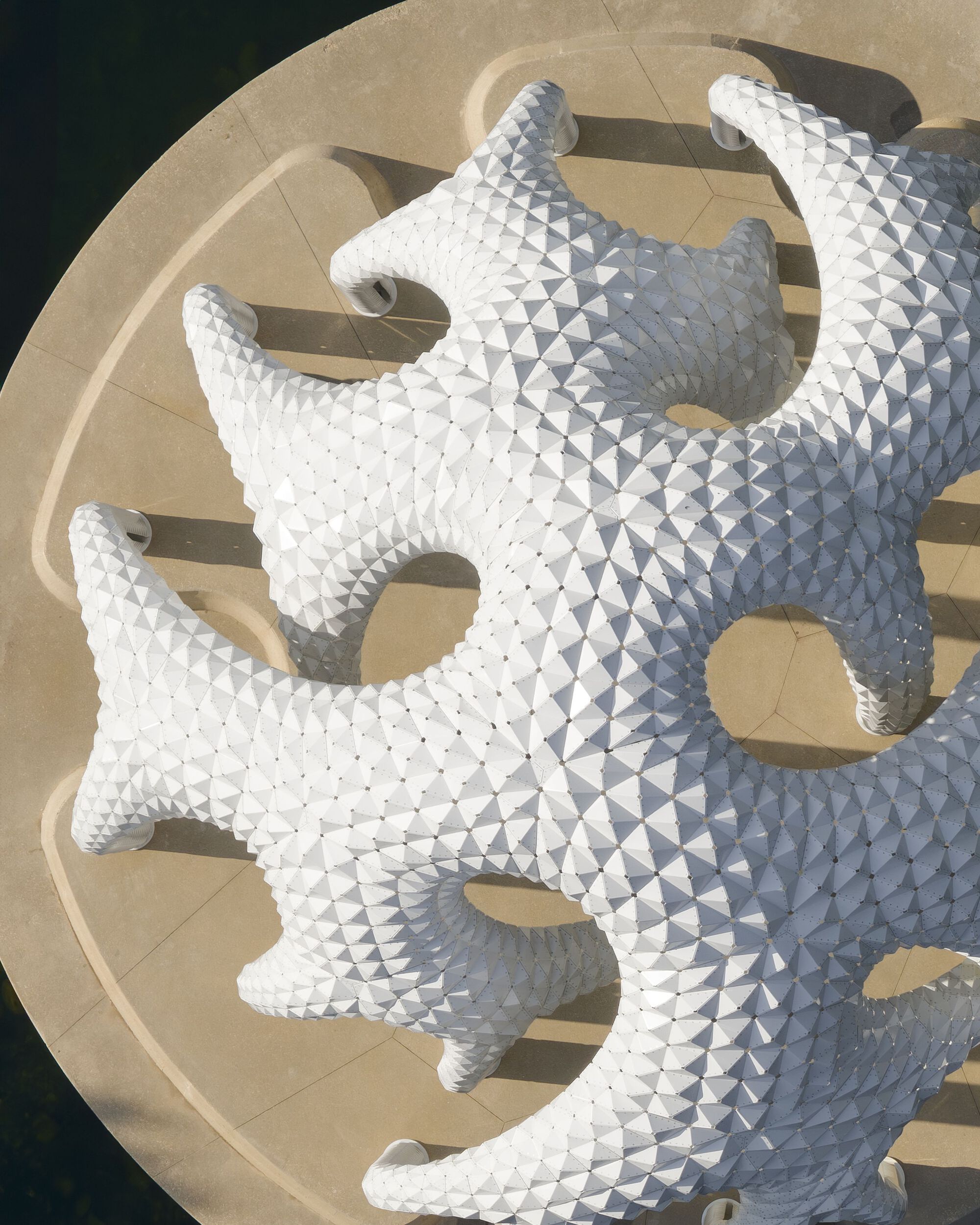 Aerial view of the white tile-clad pavilion roof with lobed openings on a circular platform