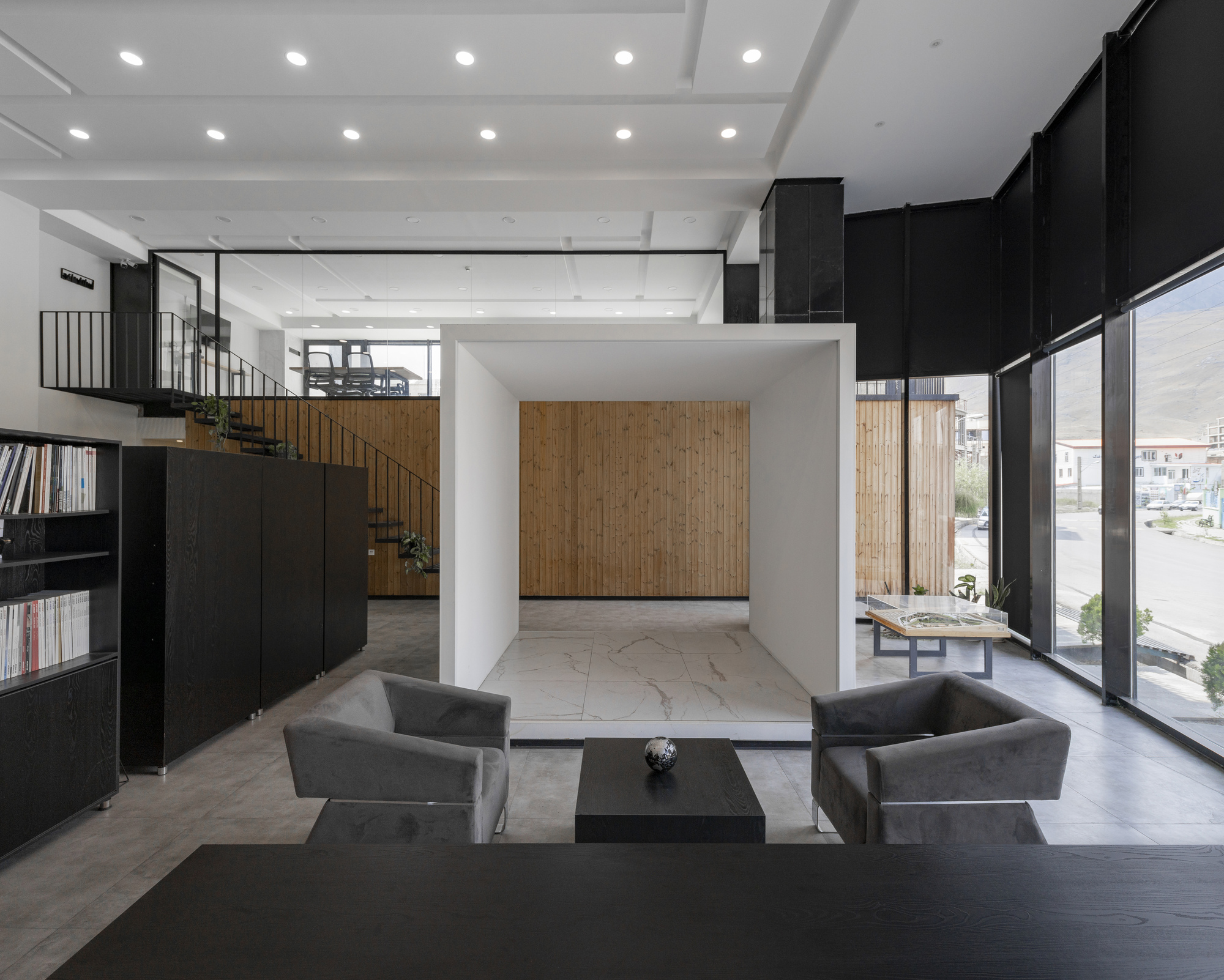 Double-height lobby with coffered white ceiling, black walls, and timber accent wall visible beyond