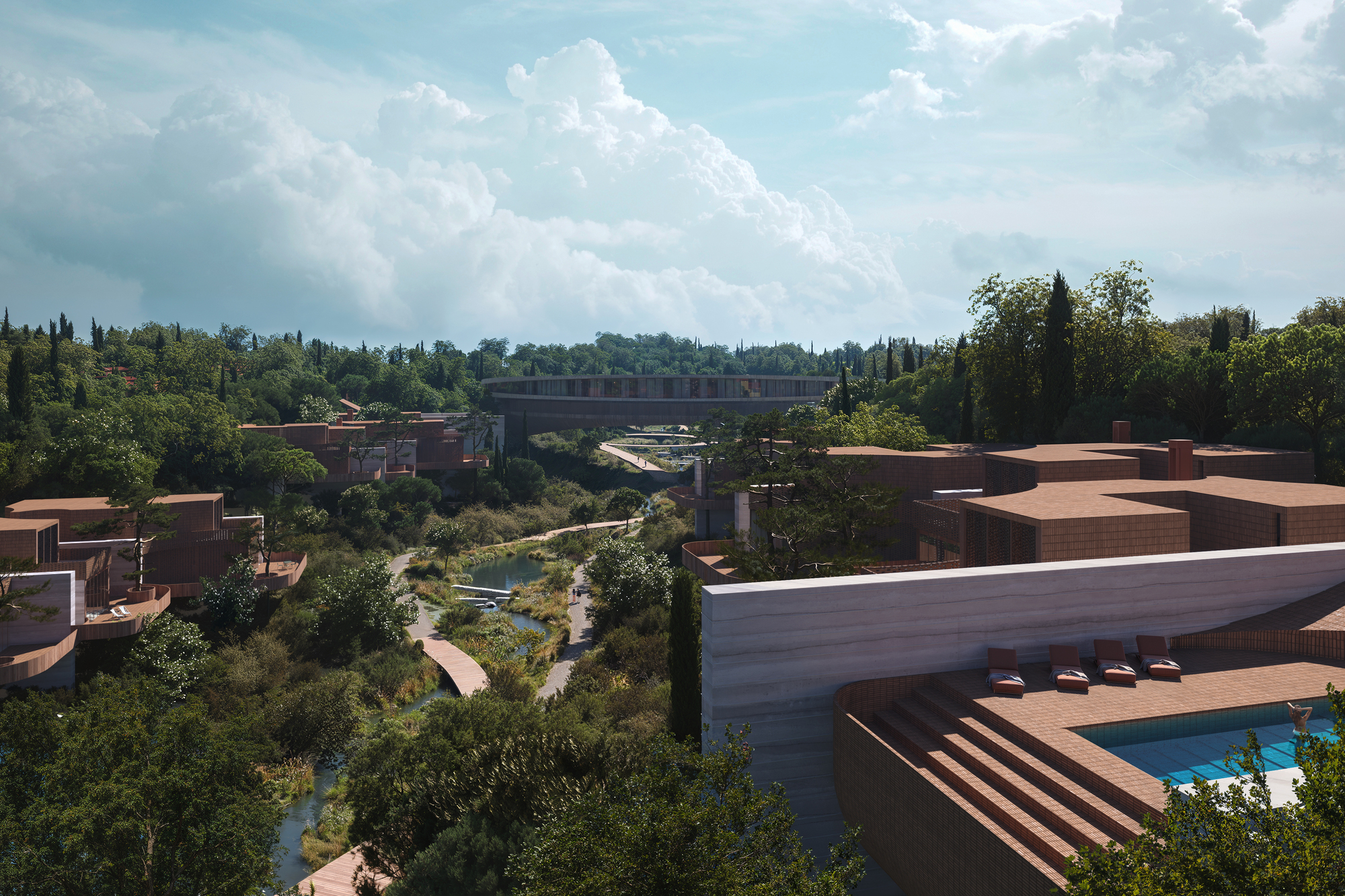 Aerial view of terracotta-roofed structures scattered across a vegetated landscape with a pond below