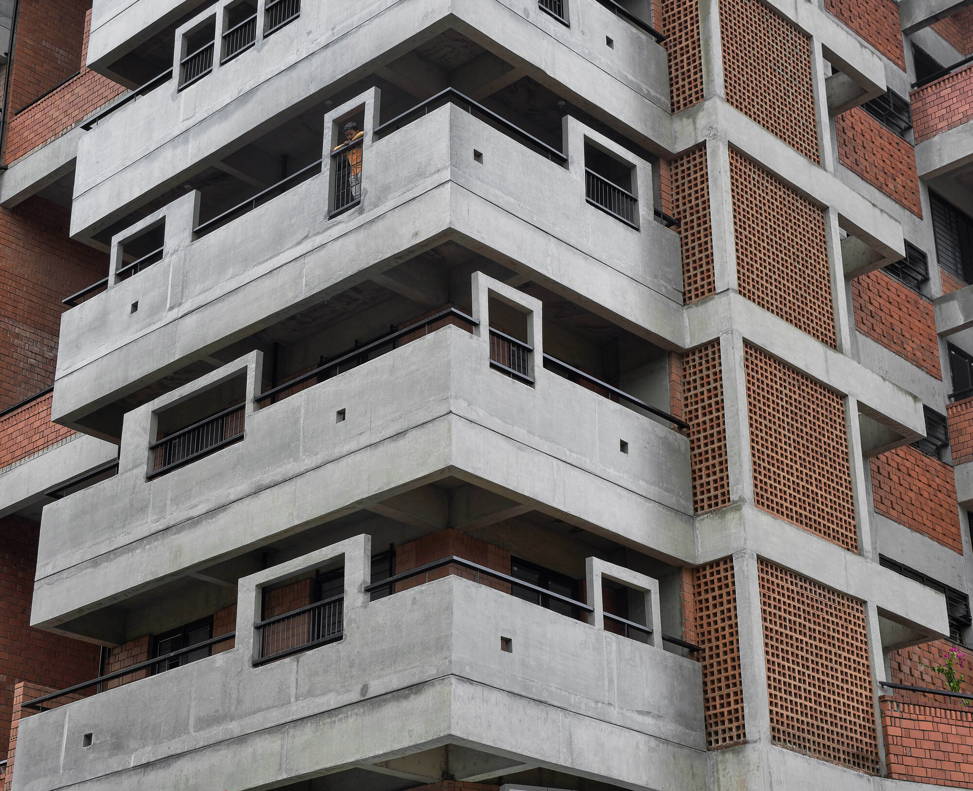 Corner detail of the concrete floor slabs with perforated brick screens set between structural columns