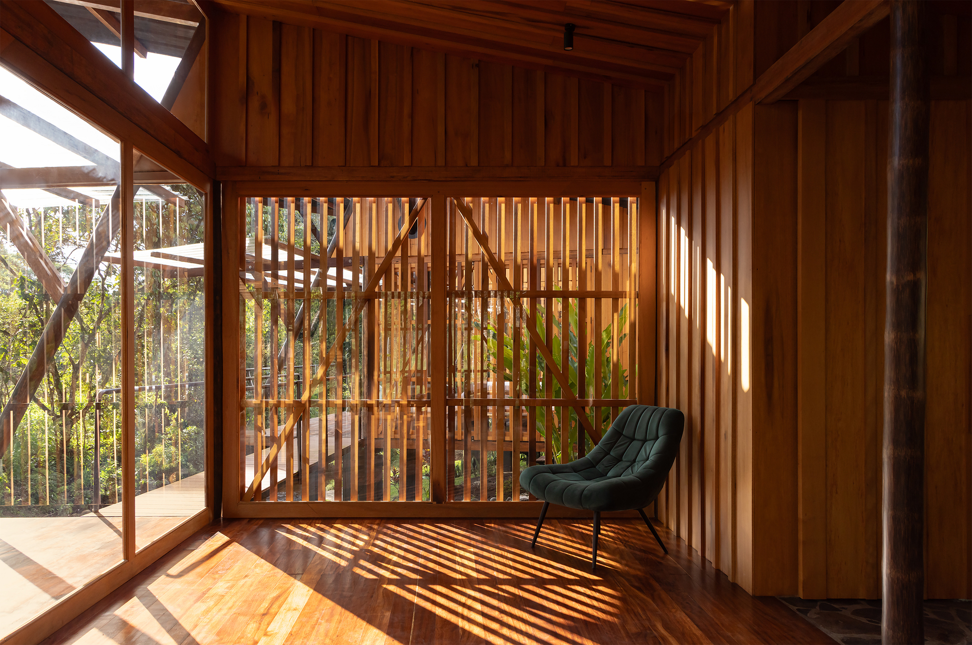 Interior corner with vertical timber slat partition casting shadows on wooden floor