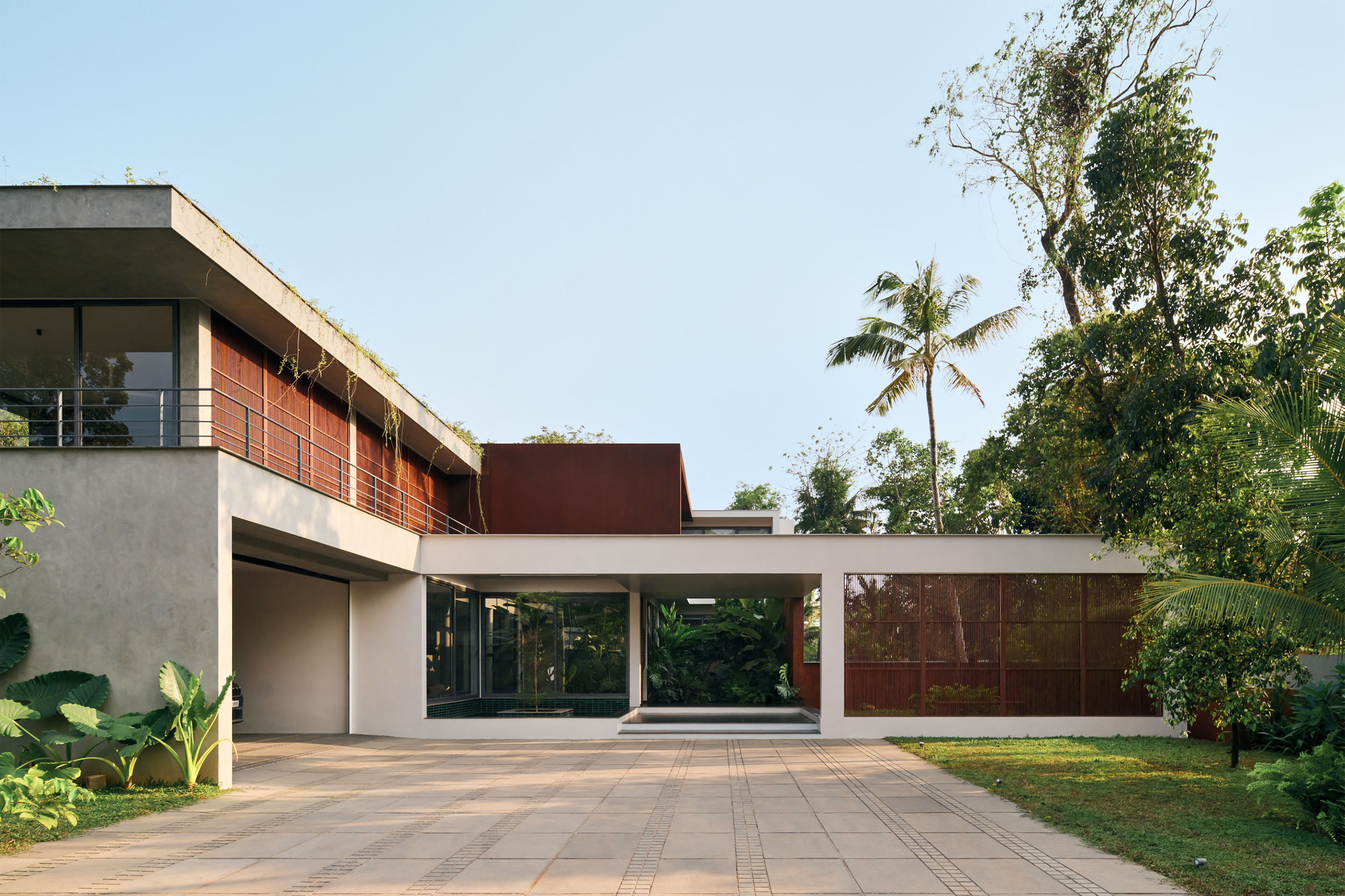 Front elevation showing the cantilevered concrete roof plane spanning between glazed and paneled volumes