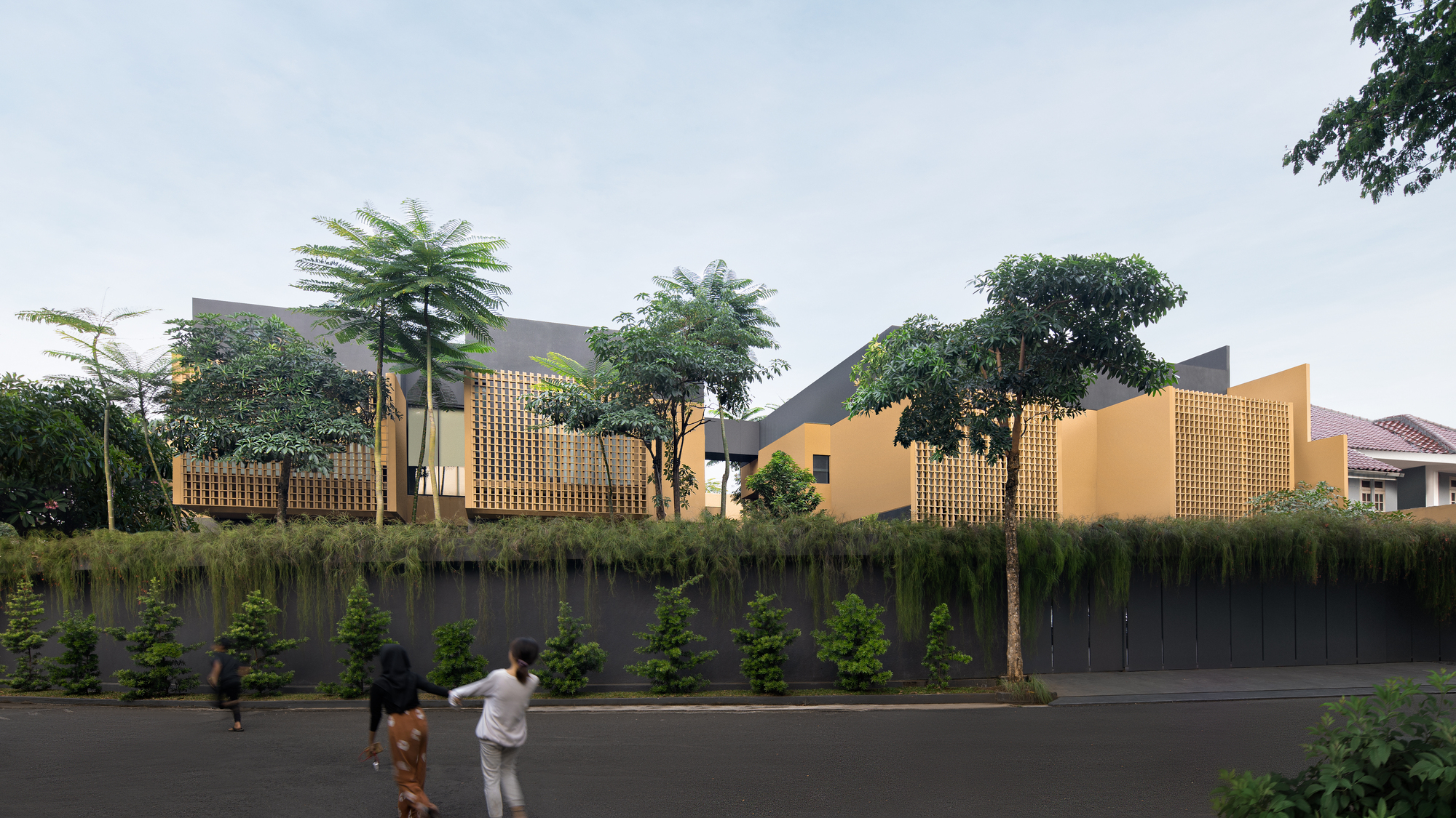 Long elevation showing lattice screens and ochre walls behind dense street-level planting with pedestrians passing