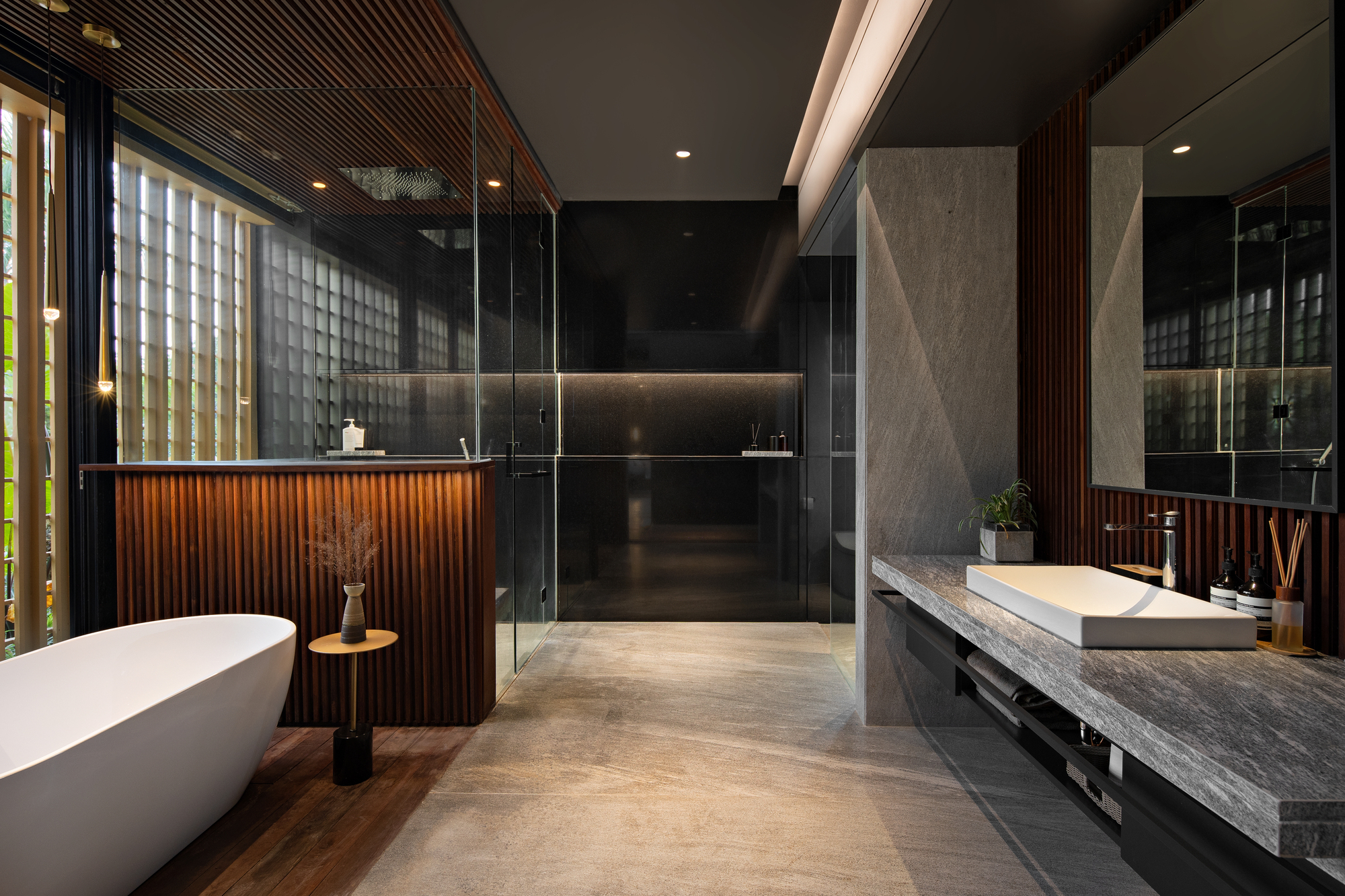 Bathroom with freestanding tub, timber slat screens, and gray stone vanity counter