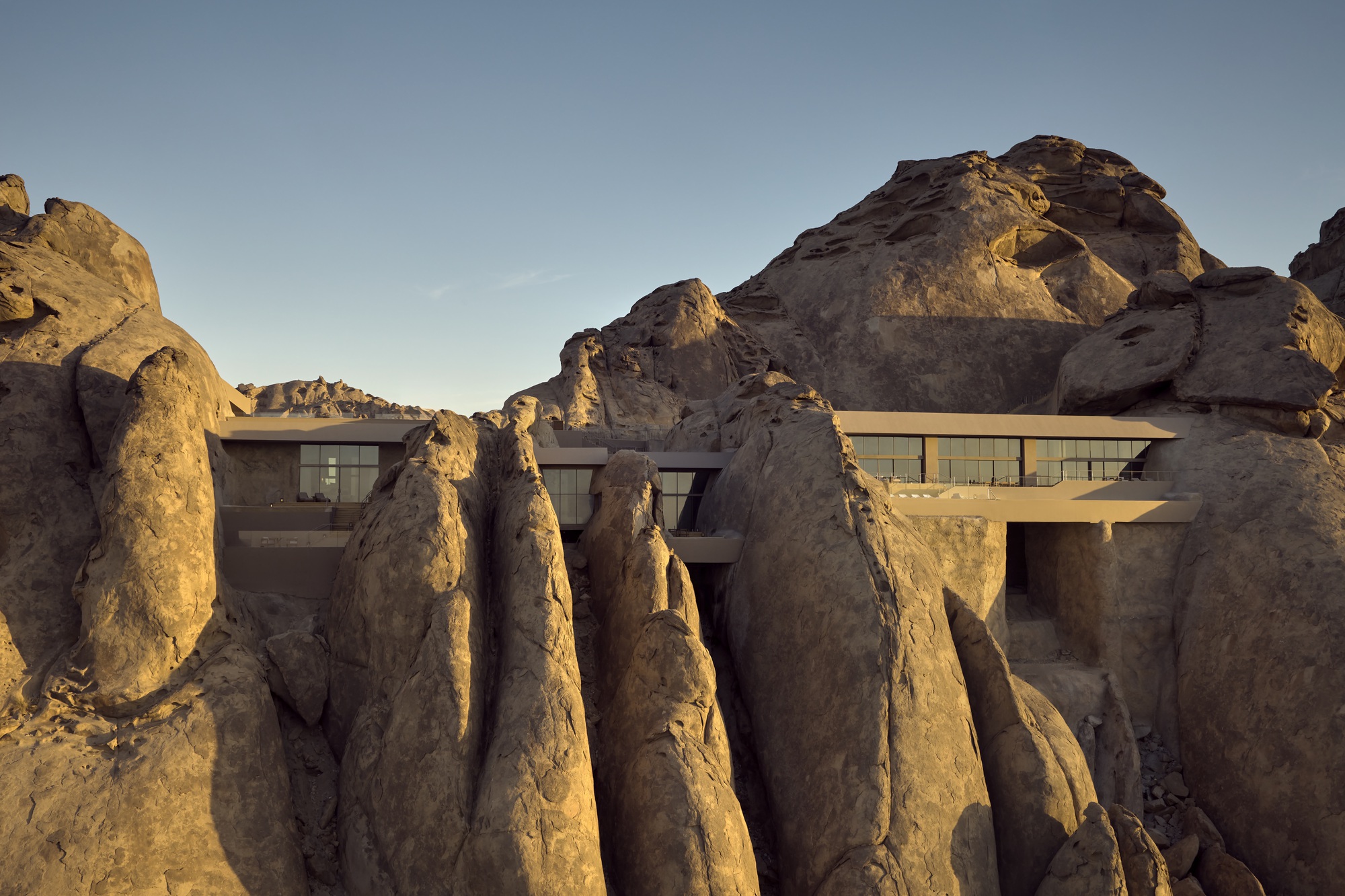 Concrete volume nestled among eroded sandstone formations in golden afternoon light
