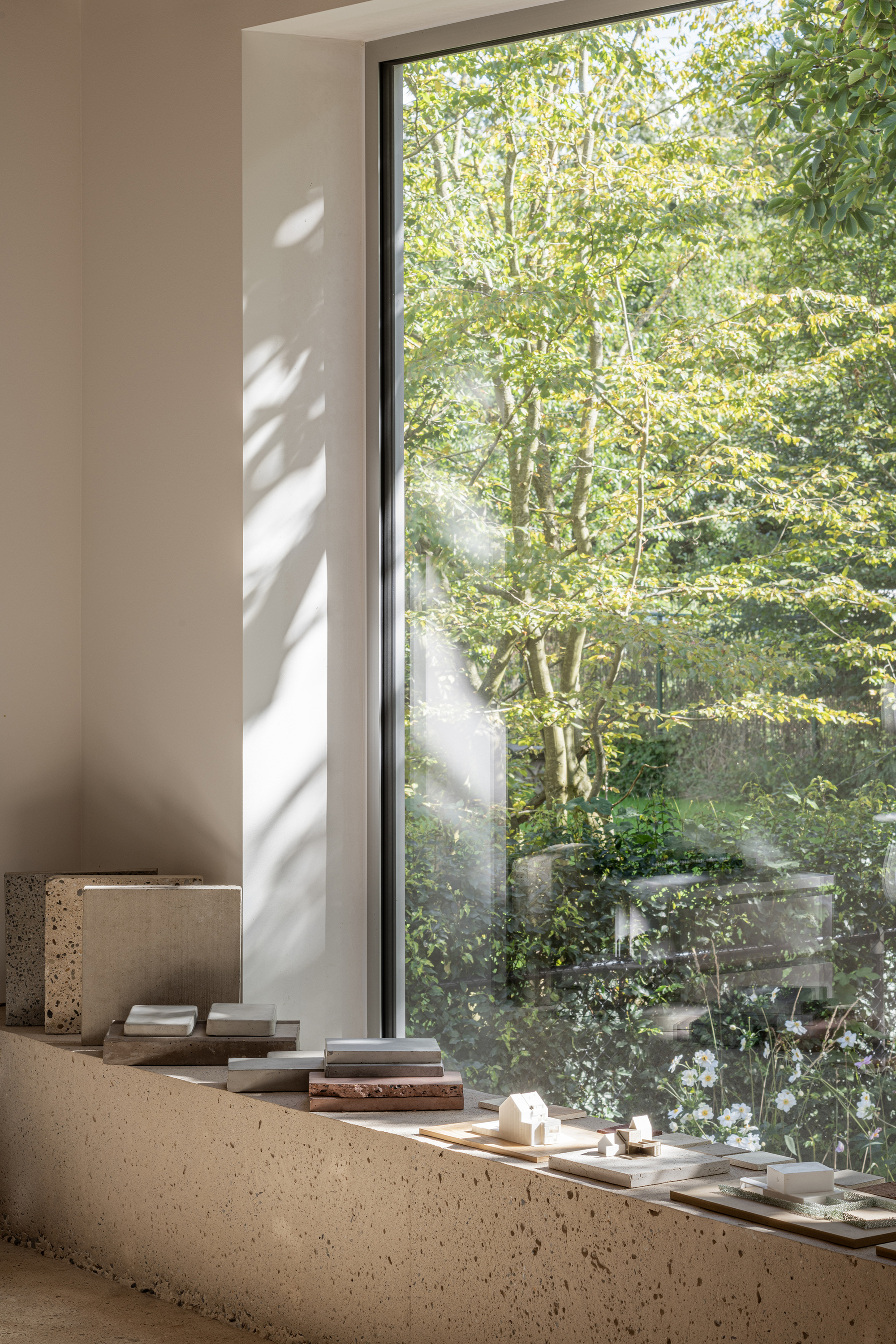 Terrazzo window sill with dappled sunlight filtering through trees outside the glazed opening