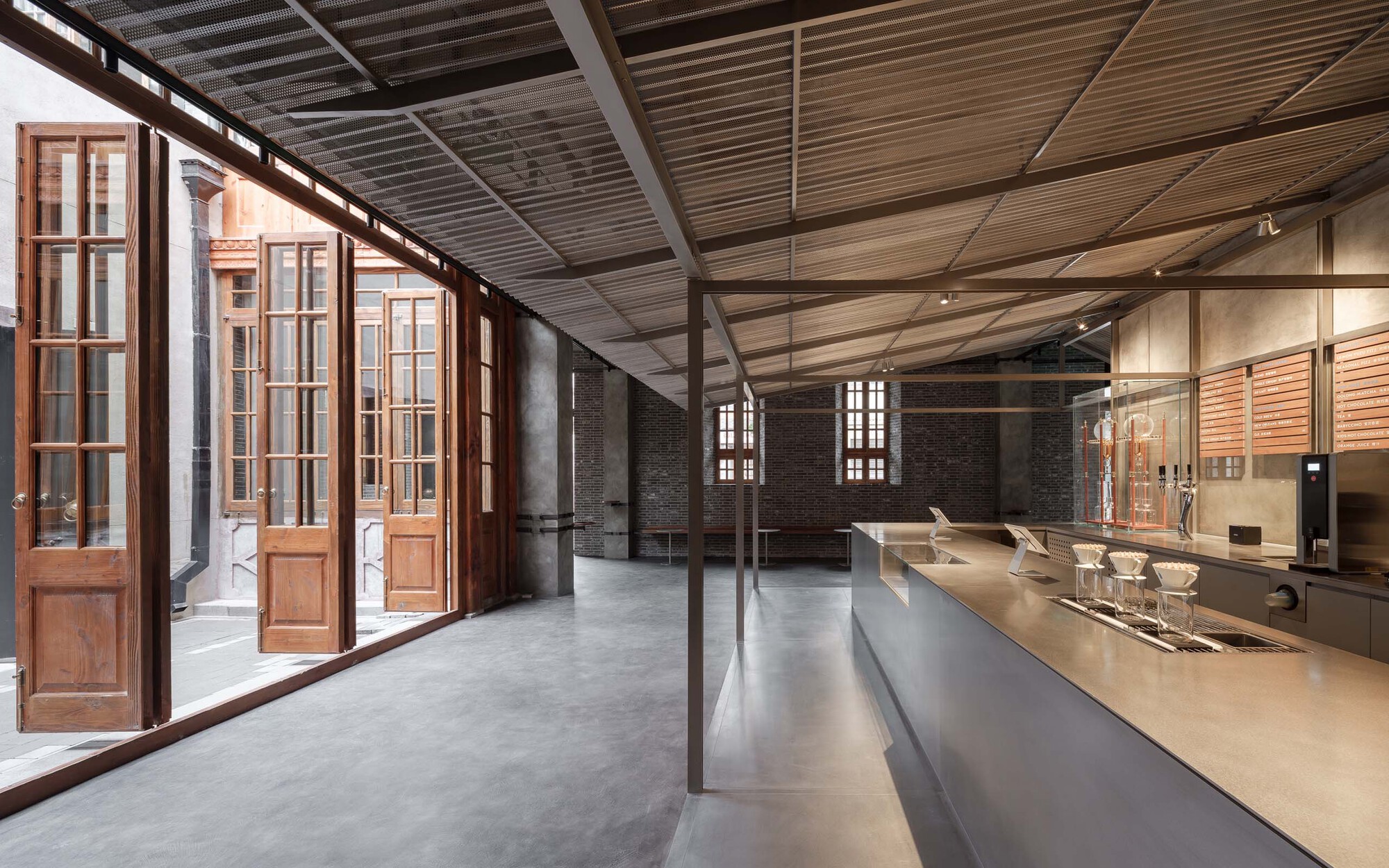 Open plan interior with folding timber doors to courtyard and stainless steel service counter
