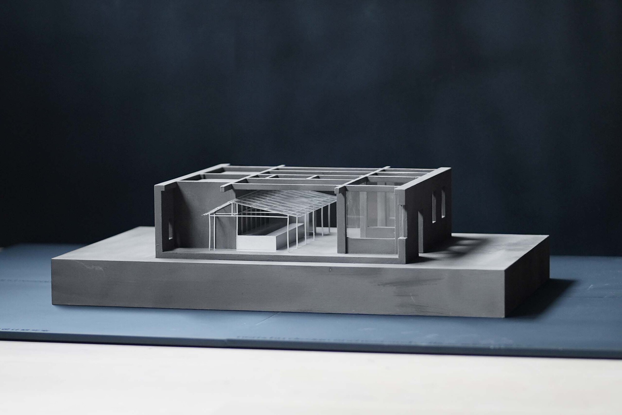 Physical model showing the gabled roof structure with exposed timber framing and interior courtyard