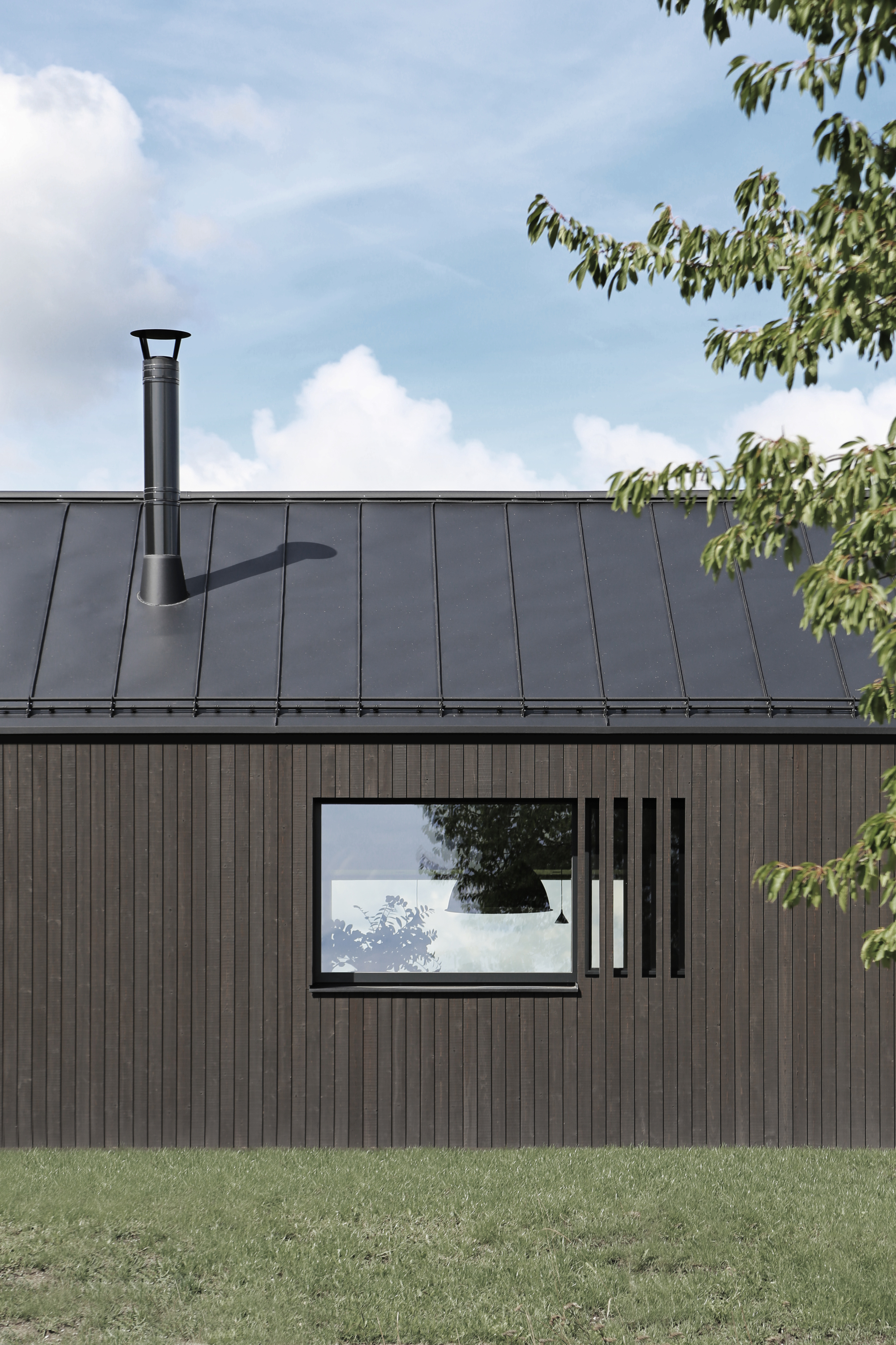 Detail of the timber facade with horizontal window and metal chimney flue on the standing seam roof