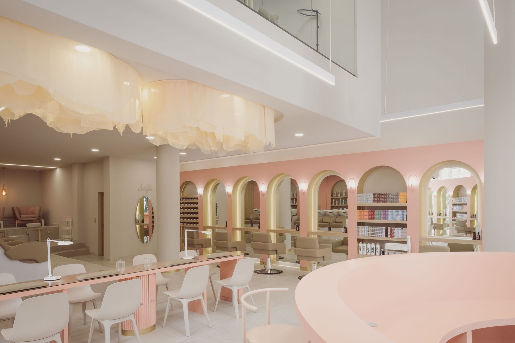 Double-height interior with a pink arcaded wall, white seating area and mural on the ceiling