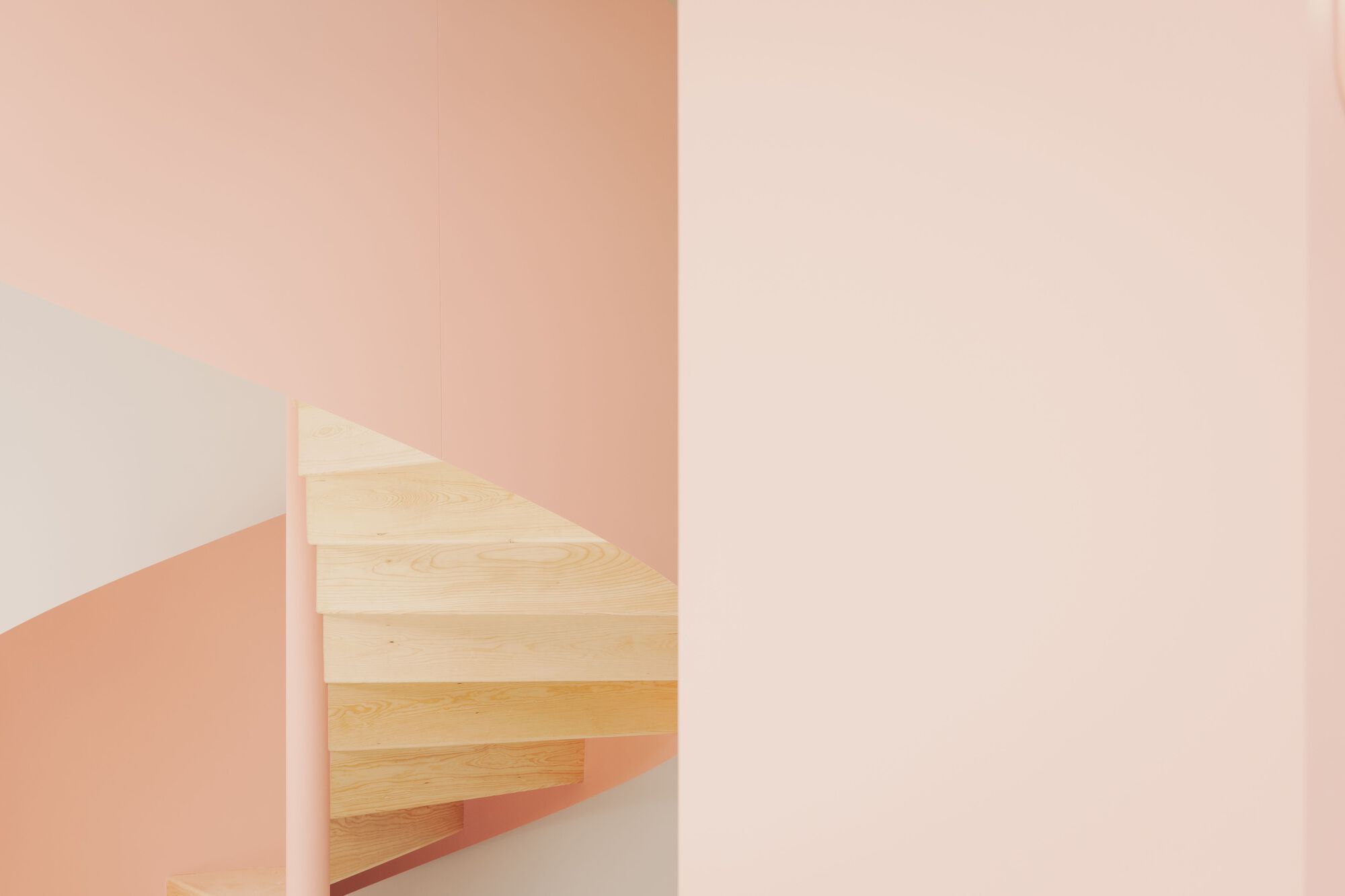 Detail of the light wood staircase treads framed by pink and white intersecting walls