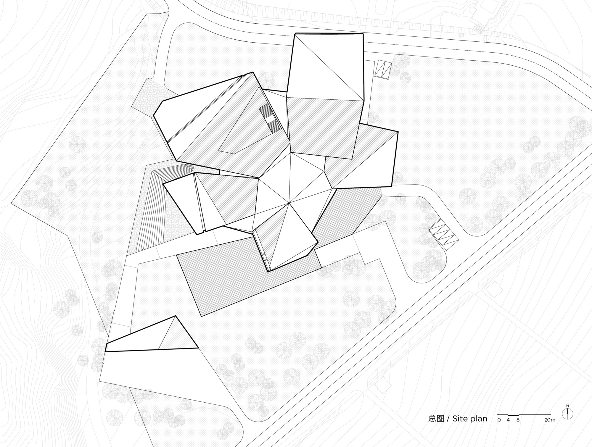 Site plan drawing showing multiple pitched-roof volumes arranged around a central courtyard with trees