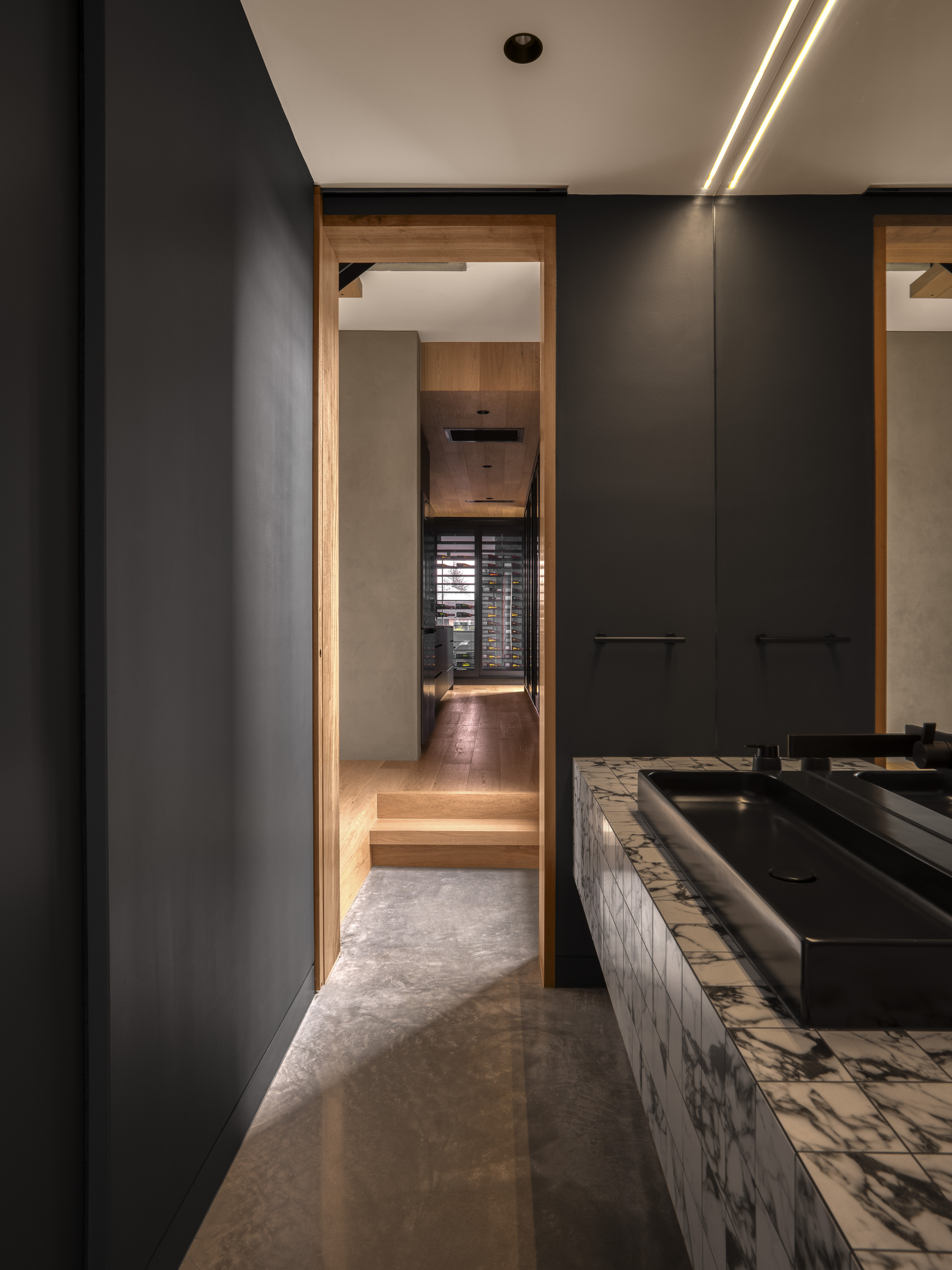 Corridor with black millwork and timber-framed doorway leading to stepped interior spaces beyond
