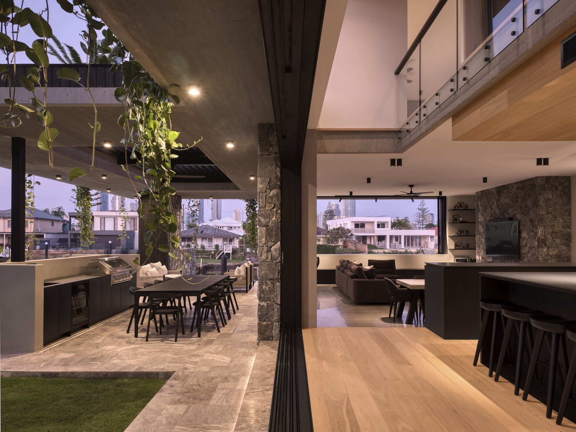 Open plan living space connecting outdoor dining area to interior through large sliding glass doors
