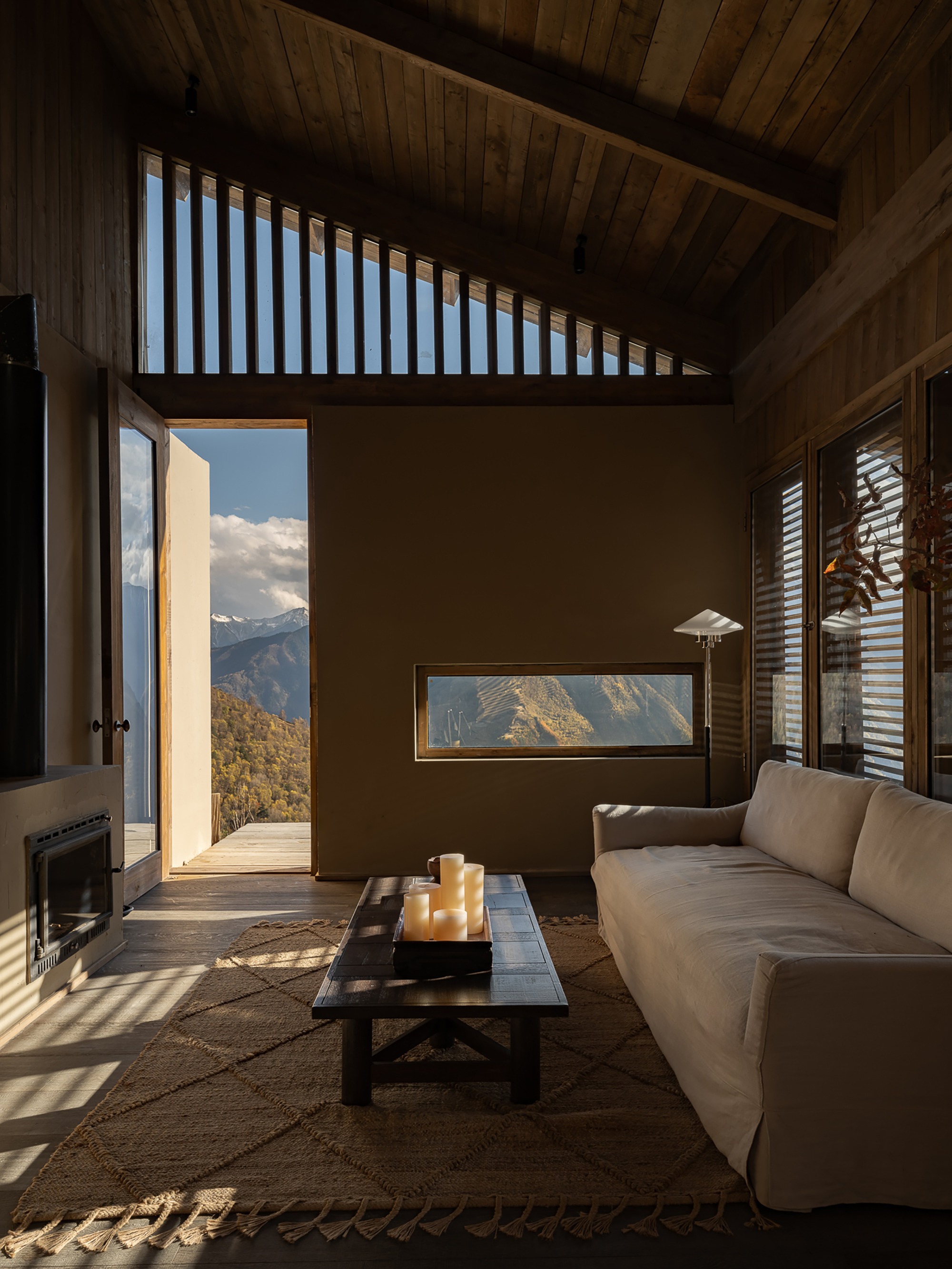 Interior space with timber ceiling and open doorway framing mountain view beyond the terrace