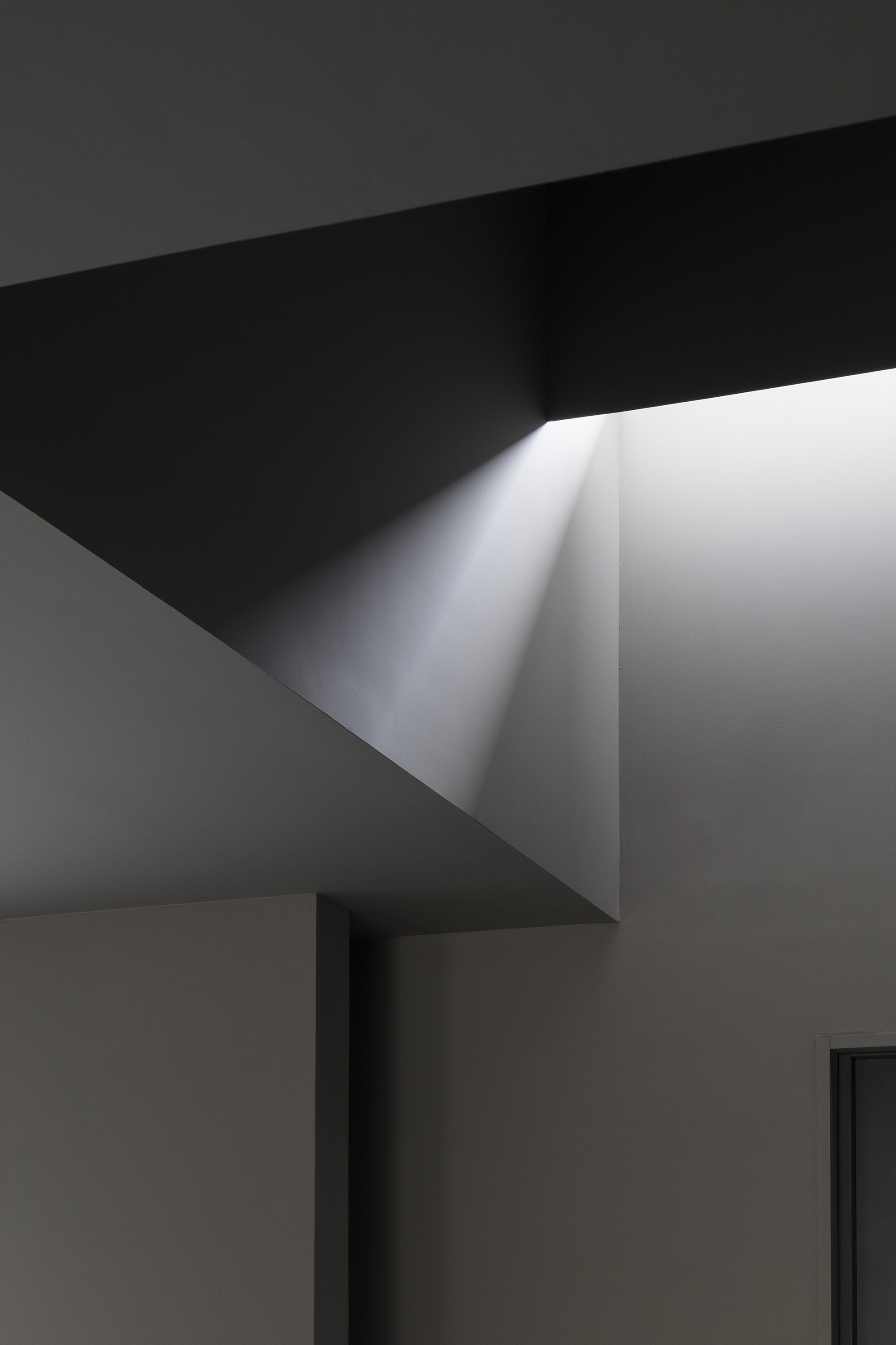 Close-up of angular ceiling geometry with concealed linear light slot at fold