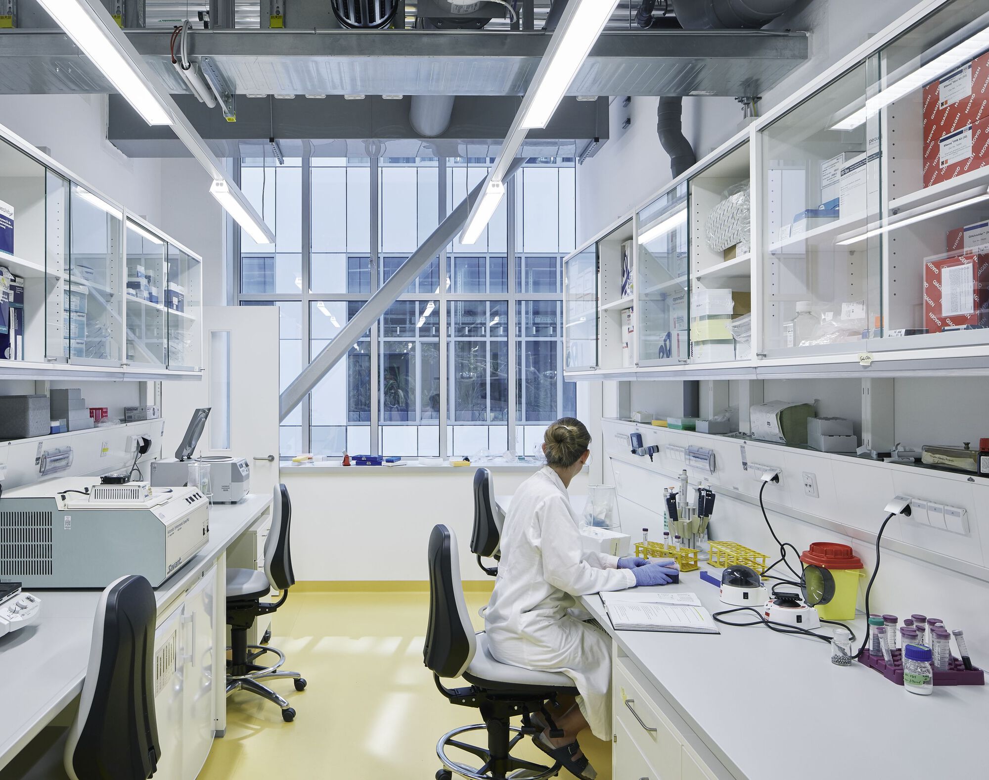 Research lab with yellow resin flooring and a technician working at a white workstation