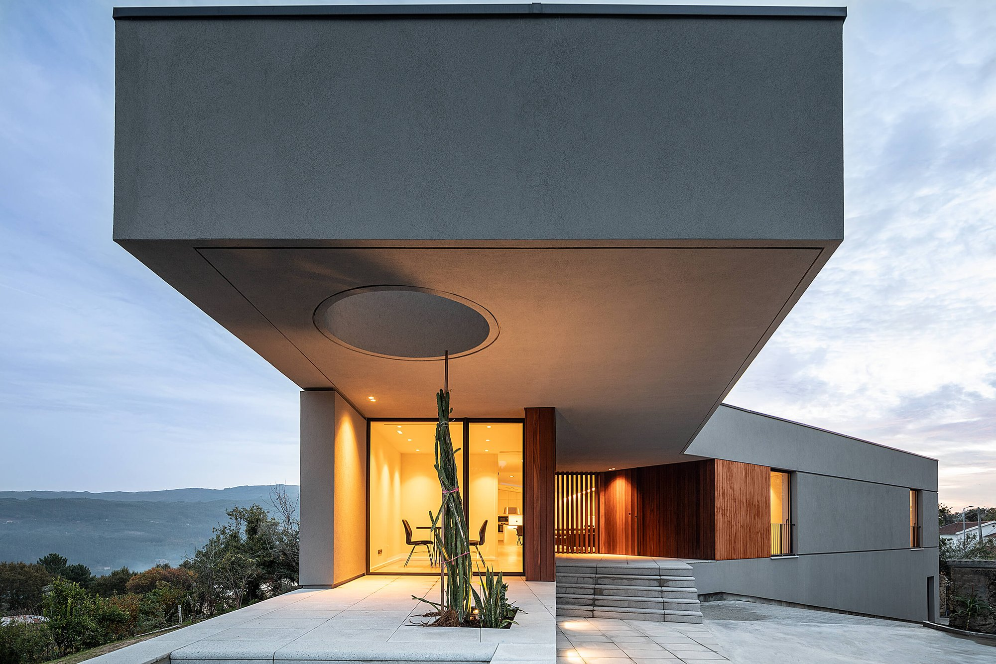 Cantilevered volume creating a sheltered entrance with a circular skylight feature.