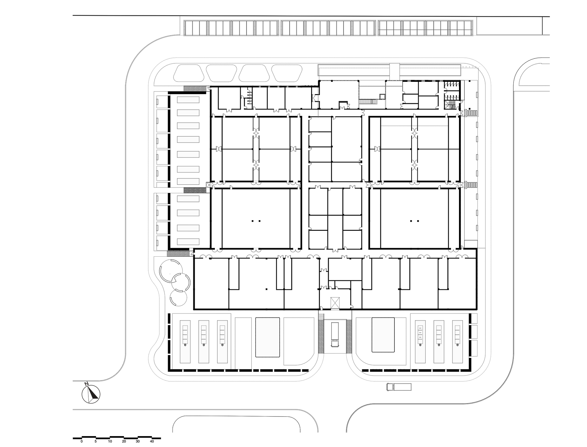Ground floor plan drawing showing a rectangular building organized around four interior courtyards with parking