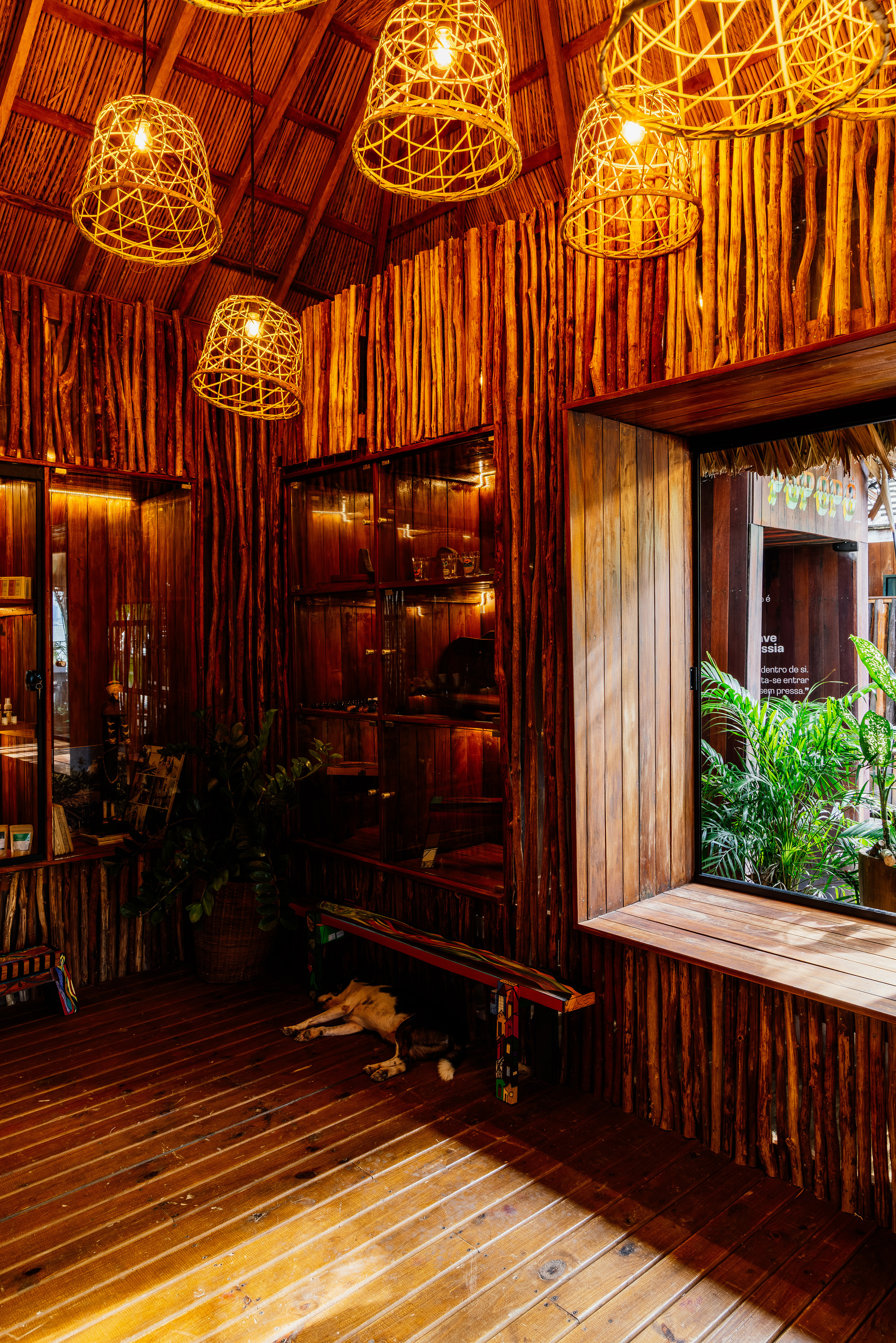 Interior with bamboo walls and woven pendant lights hanging above a timber deck floor