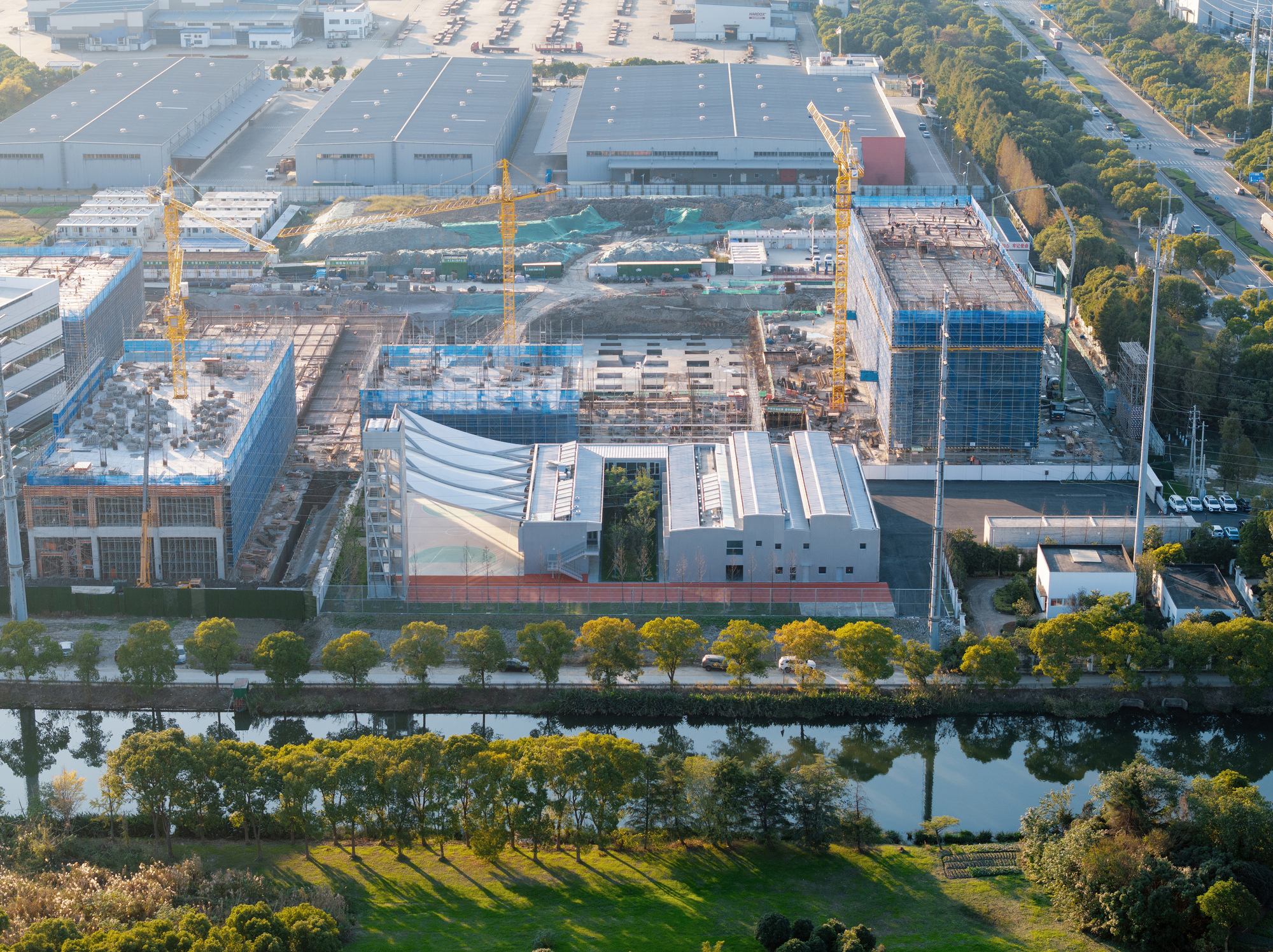 Aerial view of the construction site with tensile canopy surrounded by warehouses and a canal