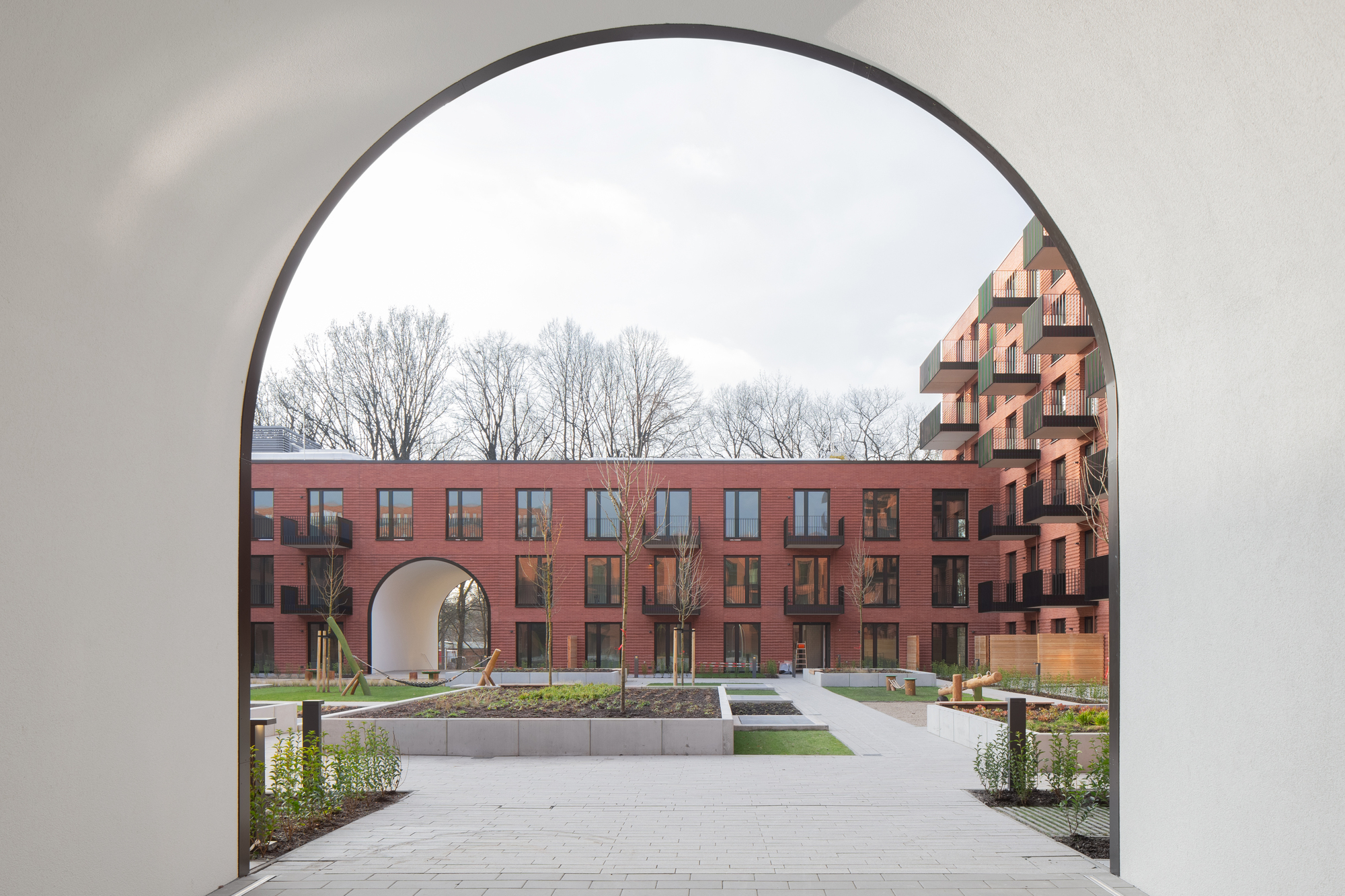 View through one archway to another framing the landscaped courtyard with bare winter trees beyond