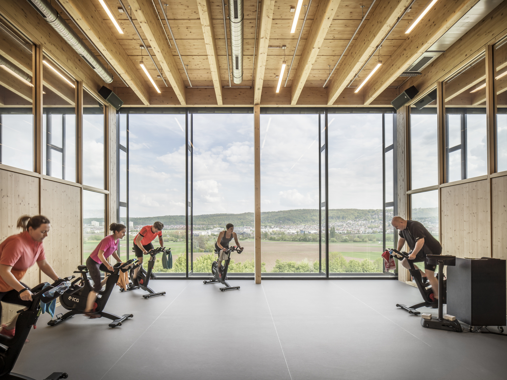 Training room with timber ceiling beams and floor-to-ceiling windows overlooking fields