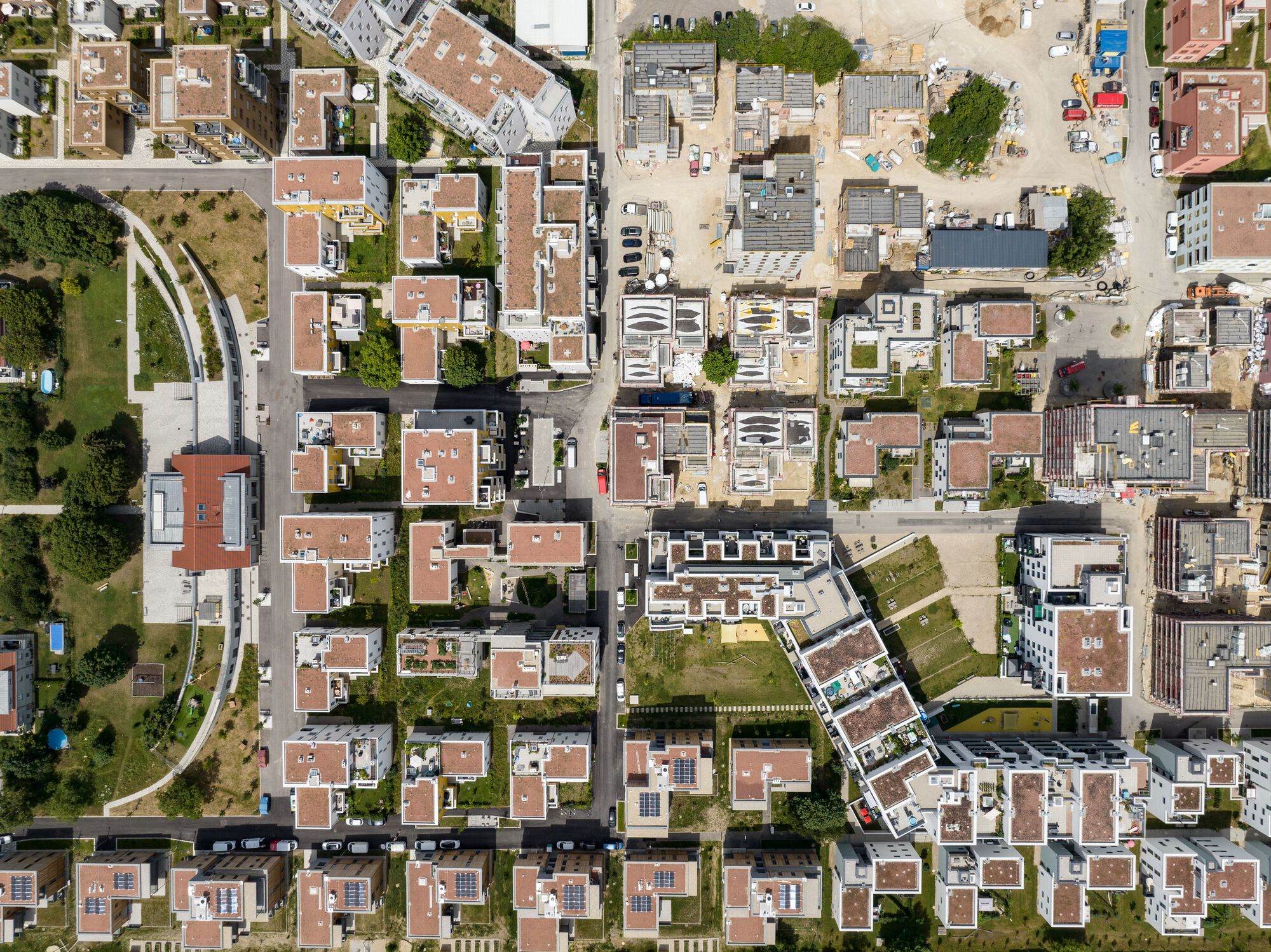 Aerial view showing residential blocks arranged around courtyards with green roofs and rooftop terraces