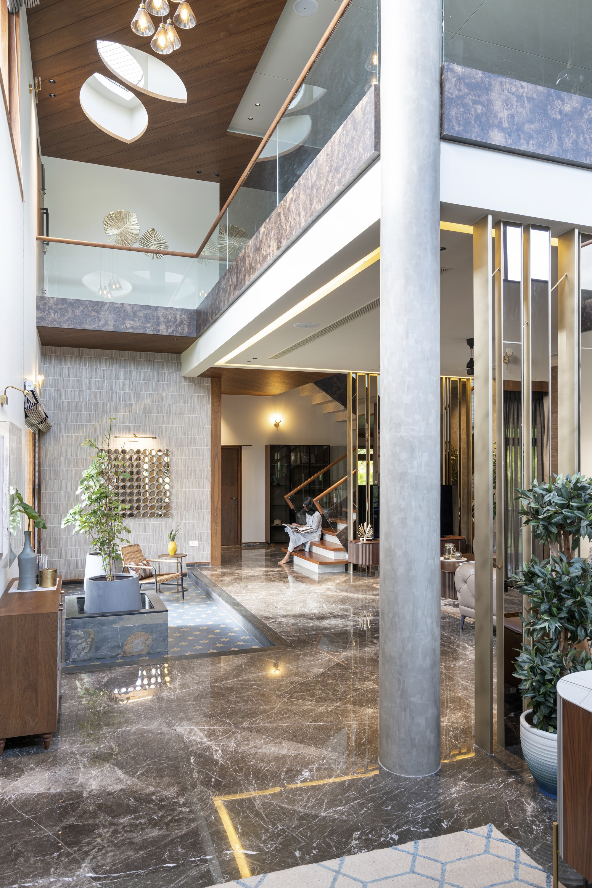 Interior atrium with exposed concrete column and timber ceiling beneath a glazed opening above