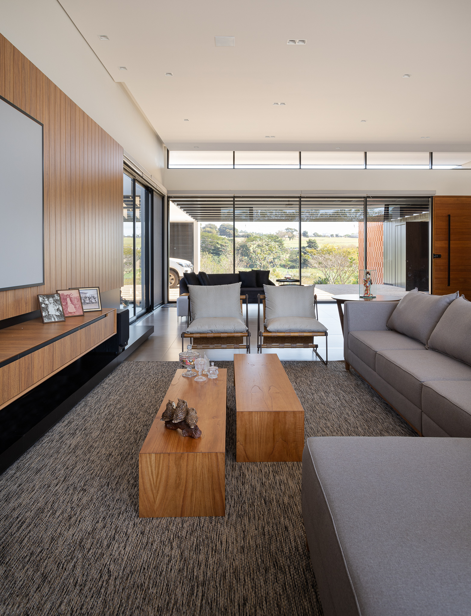 Living area with timber wall panels, clerestory windows and full-height glazing framing landscape views