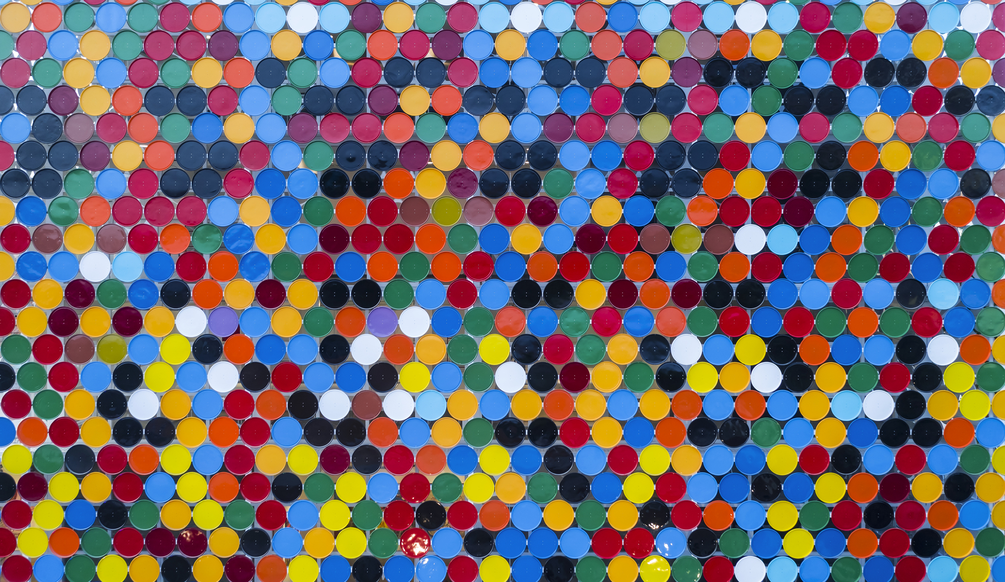 Close-up of the polychrome circular ceramic disc cladding system with visible joints