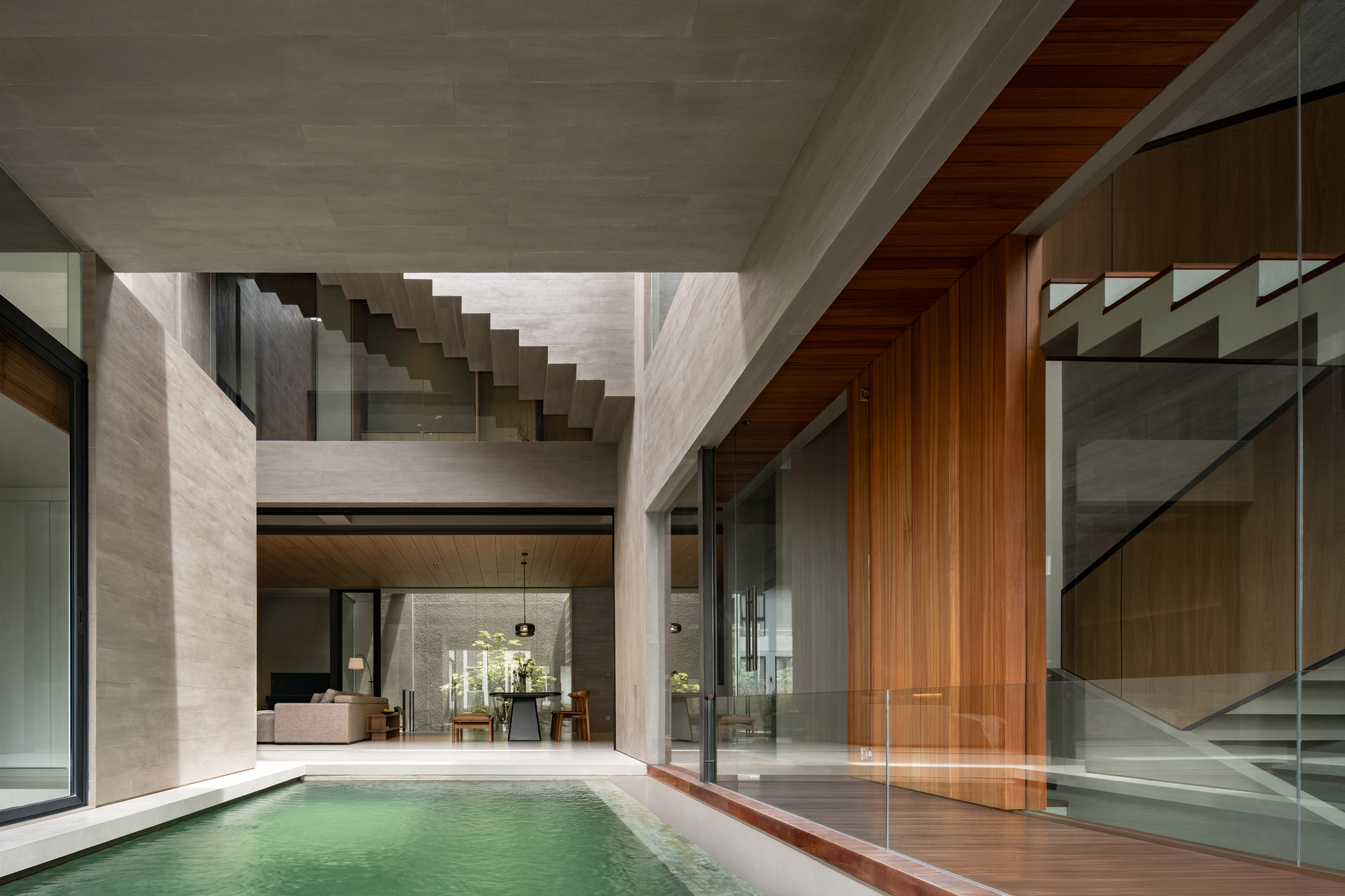 Interior courtyard with a reflecting pool framed by concrete walls and a timber-lined soffit