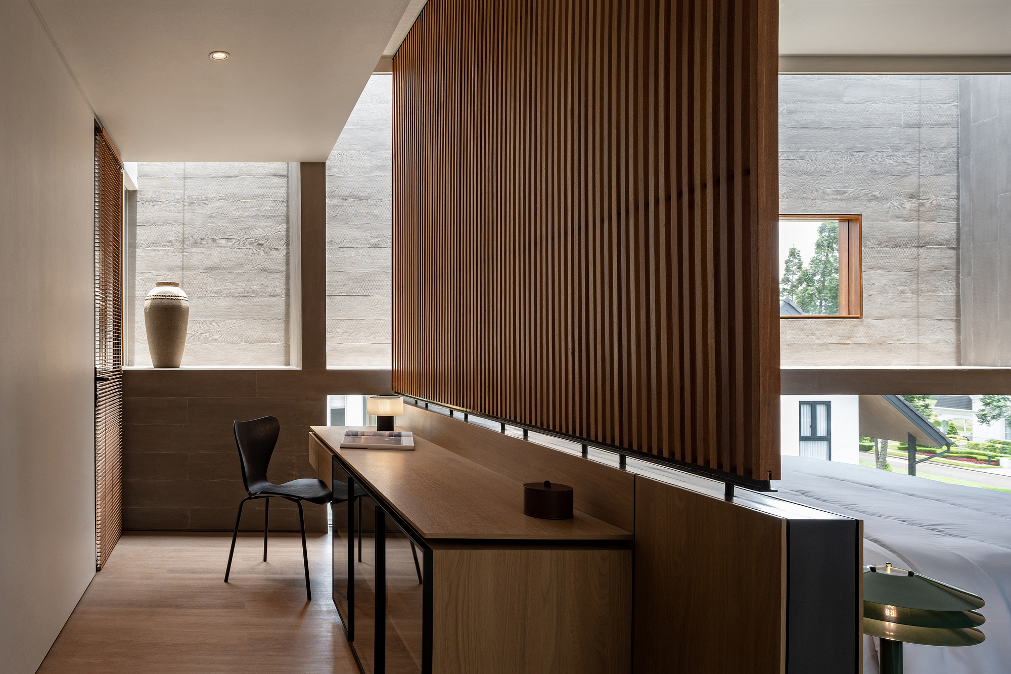 Study area with vertical timber slat screen and desk overlooking a double-height space
