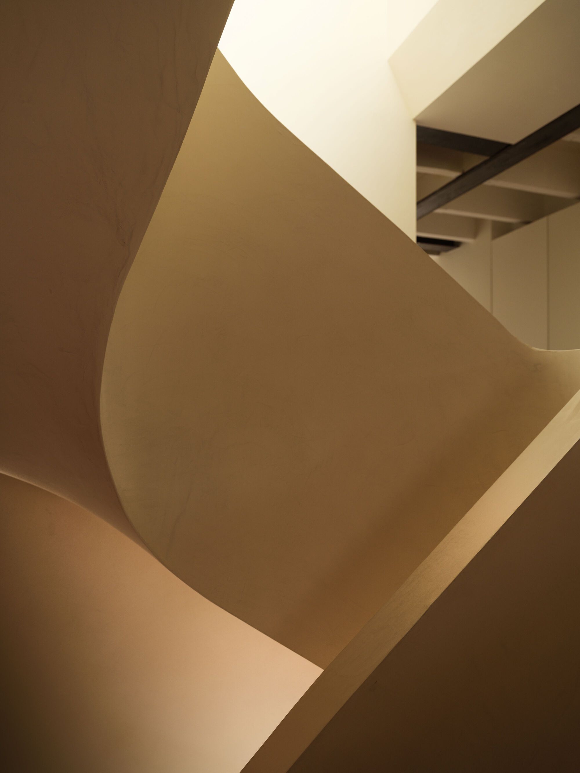 Abstract view of sculptural staircase volumes intersecting under ambient daylight