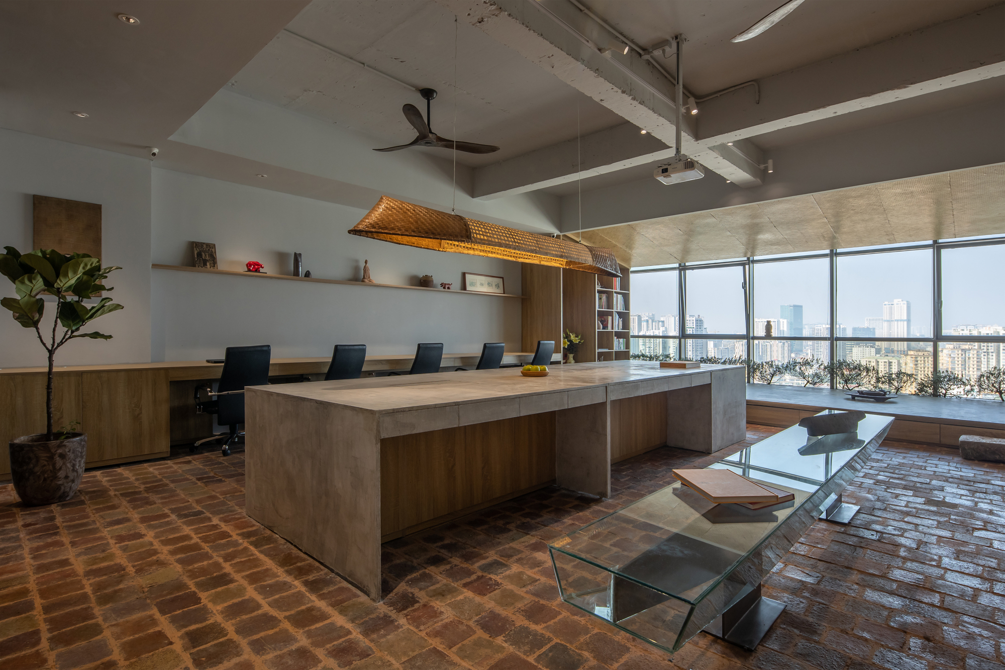 Conference table with woven pendant light and floor-to-ceiling windows overlooking the city skyline
