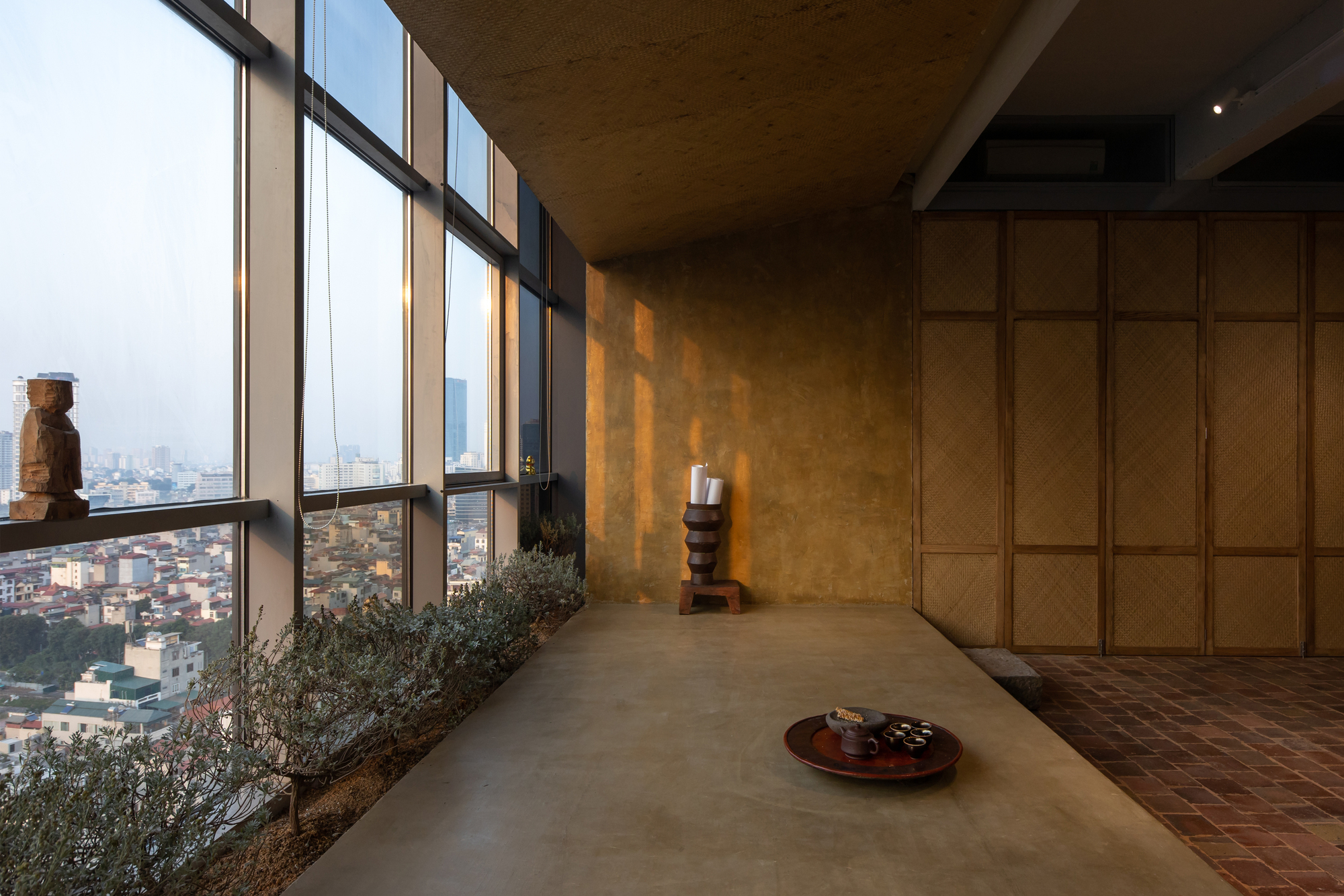Interior corridor with floor-to-ceiling windows overlooking the cityscape and planted bed along the sill