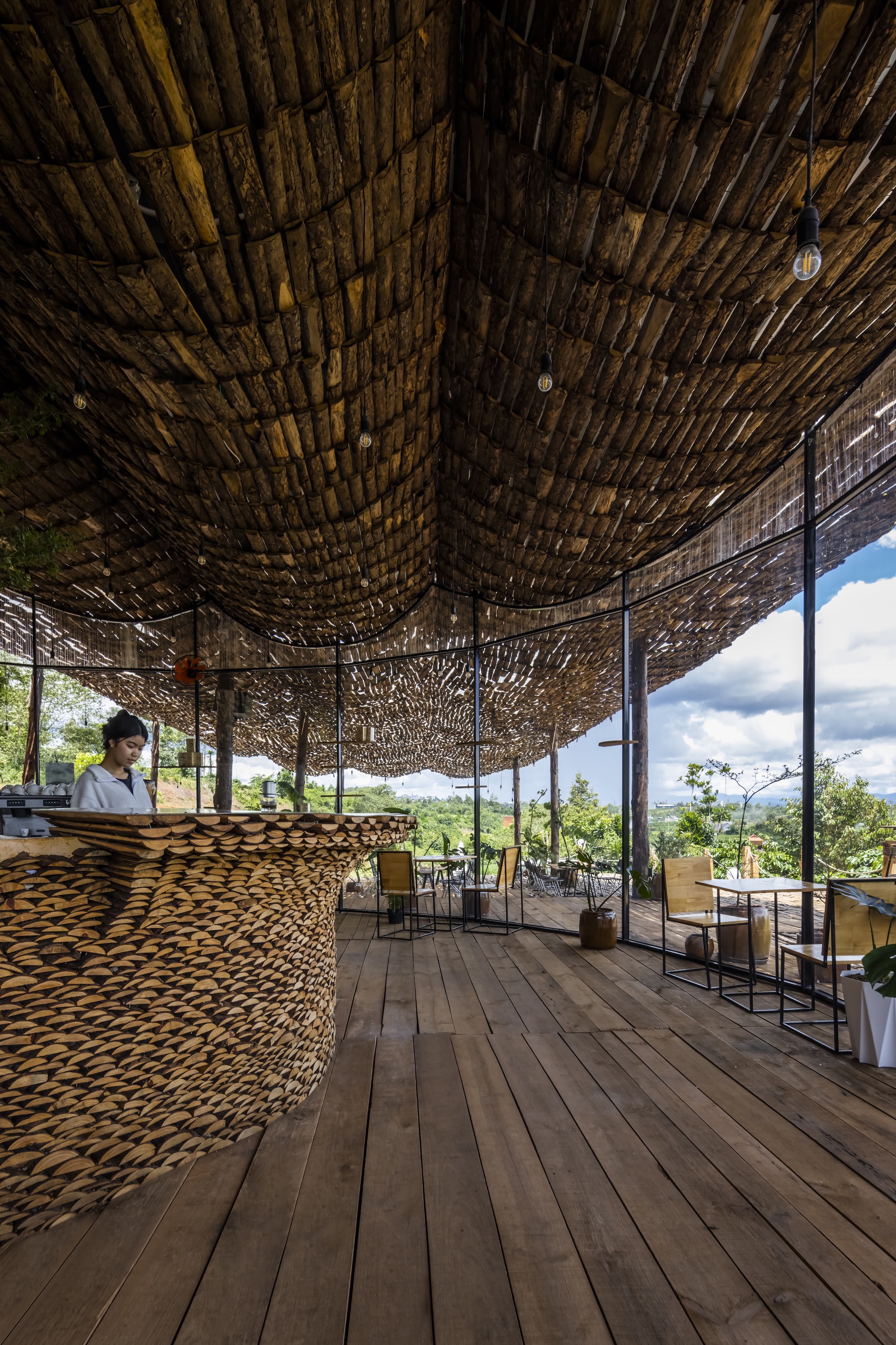 Interior view of the woven bamboo ceiling with curved timber columns and a reception counter