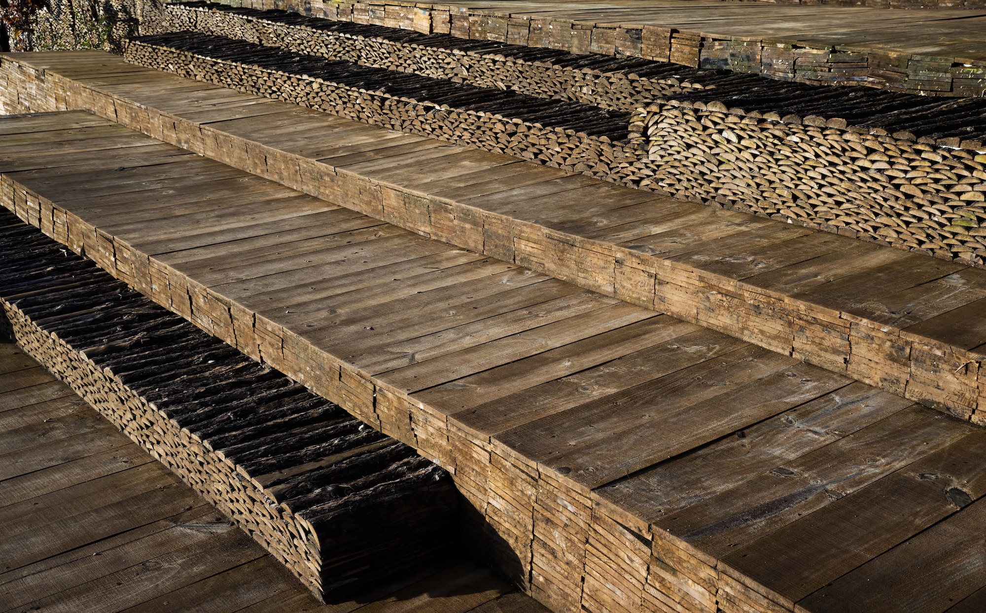 Close-up of tiered bamboo deck construction showing split poles and timber beams