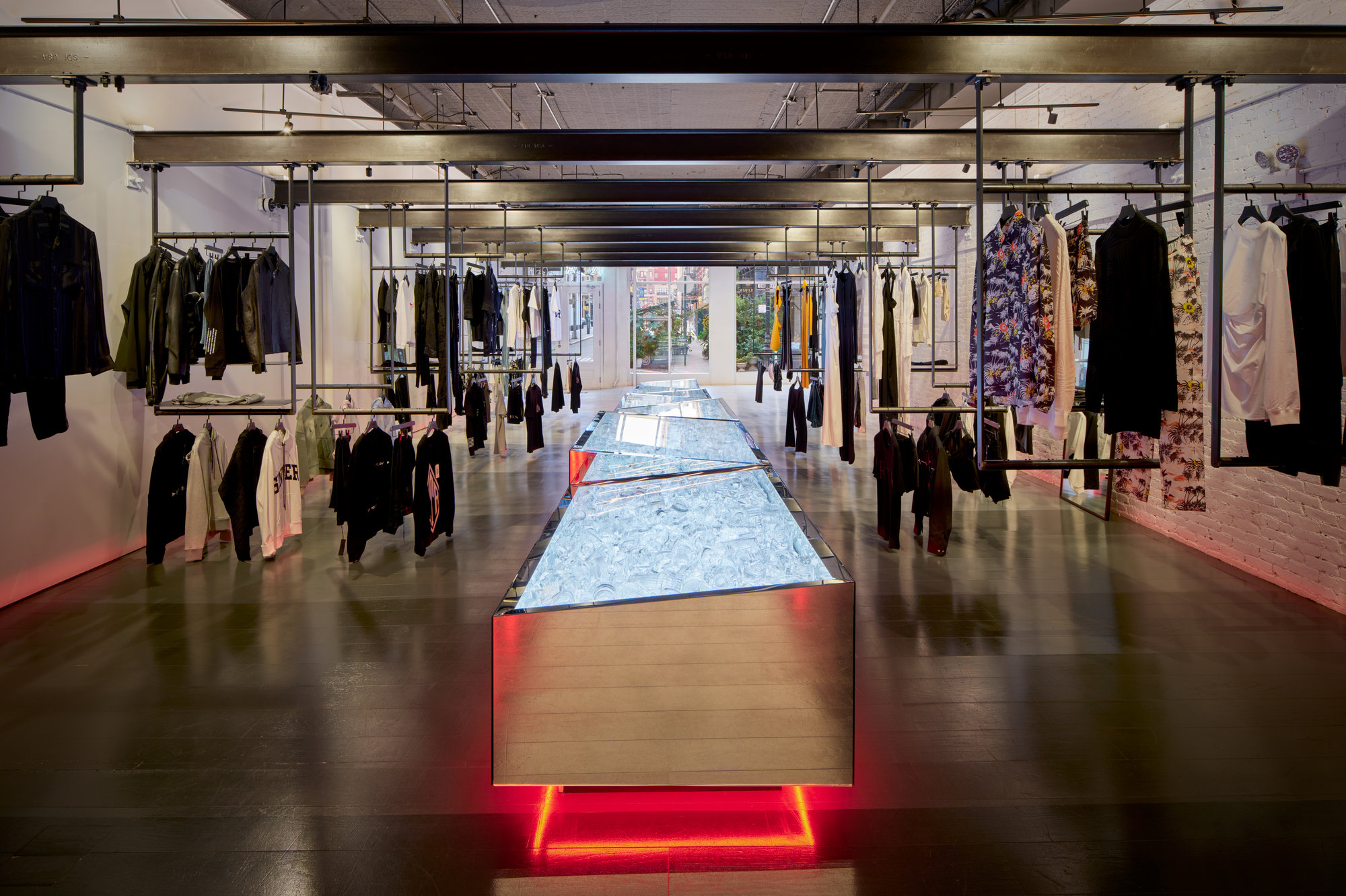 Retail floor with illuminated table runway extending toward street windows visible in the distance
