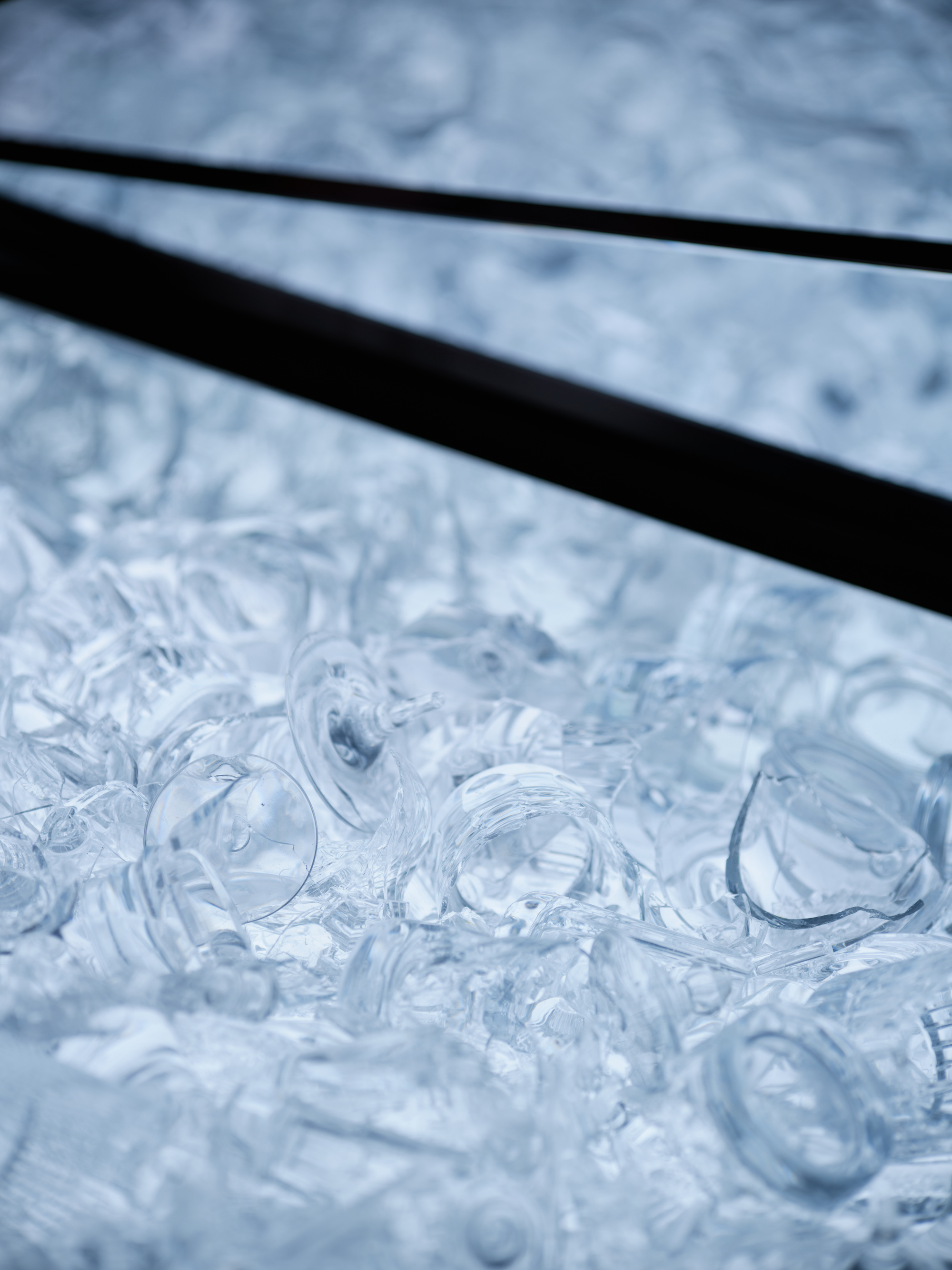Angled view across textured glass panels showing swirling relief patterns and dark metal dividers