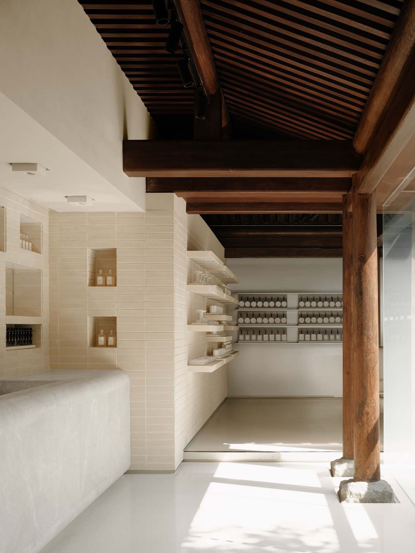 This architectural image showcases a minimalist retail space with a blend of modern and traditional elements. The design features clean lines, white walls, and